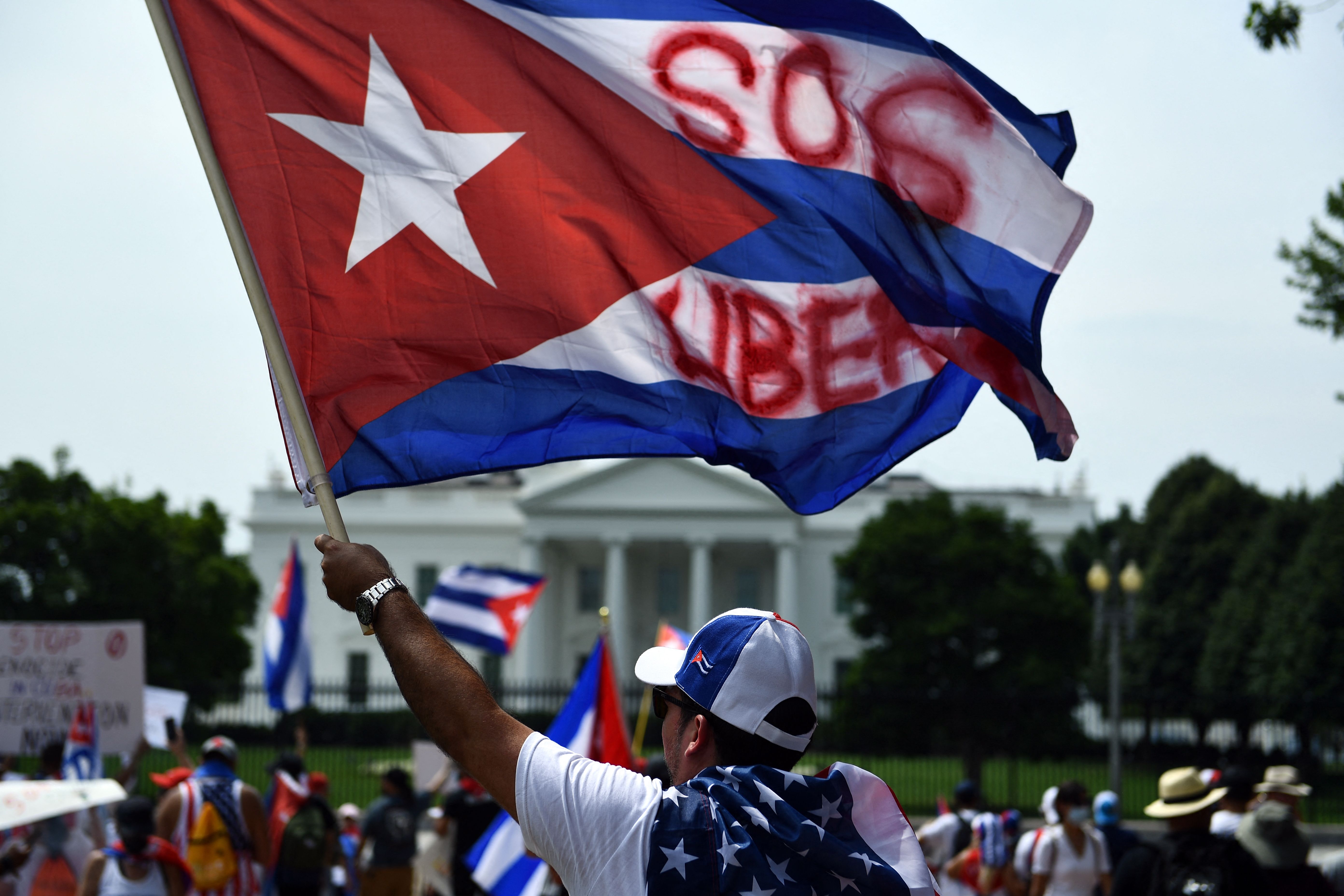 People gather for a Cuba protest as people wave signs and Cuban flags in Lafayette Square near the White House in Washington DC, on July 26, 2021. - Right-leaning Latin American governments and other US allies joined Washington on Monday in urging Cuba to respect rights and free people detained in unprecedented mass protests. (Photo by Brendan Smialowski / AFP)