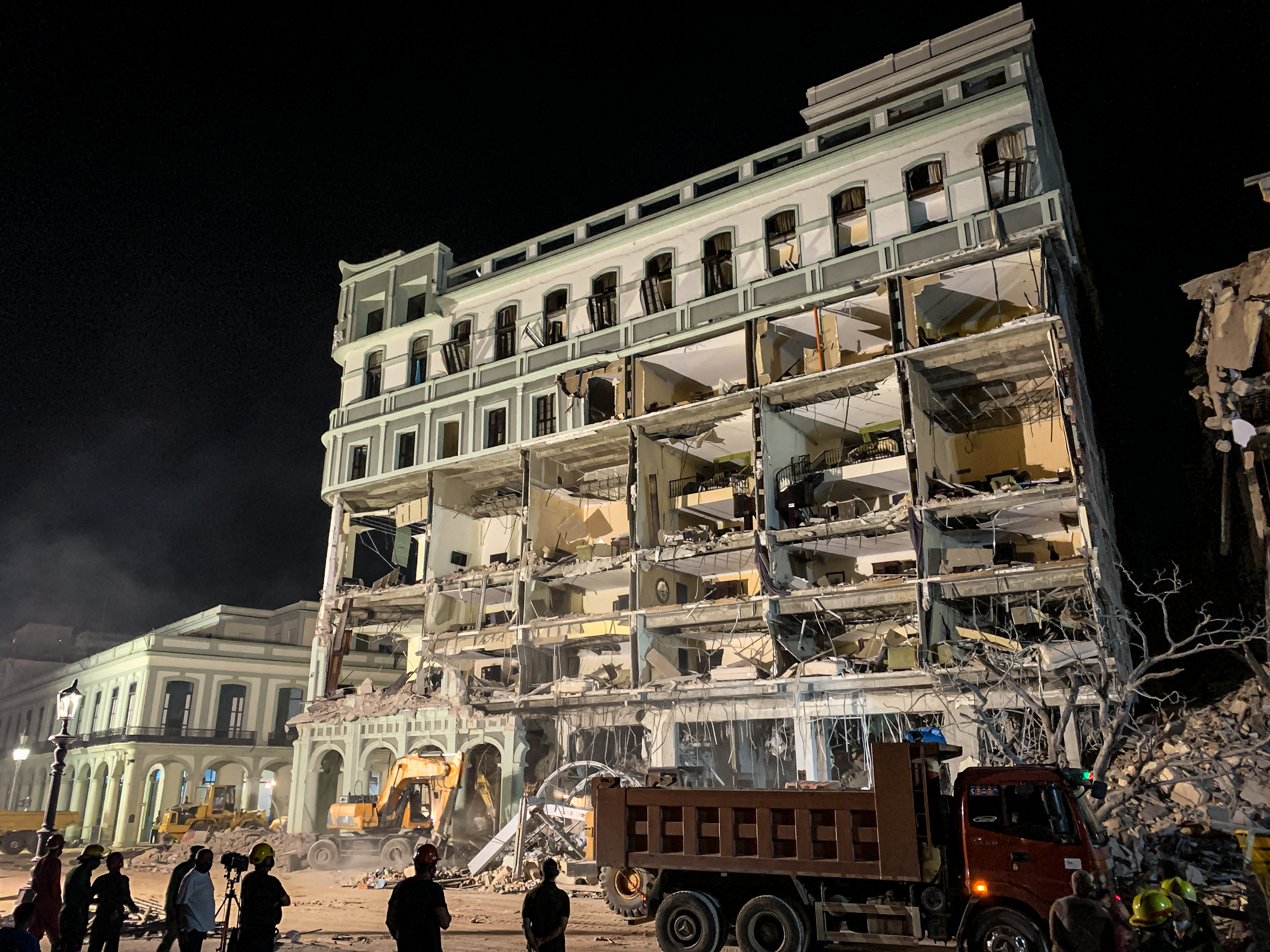 Firefighters remove debris from the ruins of the Saratoga Hotel, in Havana, on May 6, 2022. - The death toll from a powerful explosion at a five-star hotel in central Havana climbed to 22 on May 6 with more than 50 people injured after a suspected gas leak, according to official tallies. (Photo by ADALBERTO ROQUE / AFP)