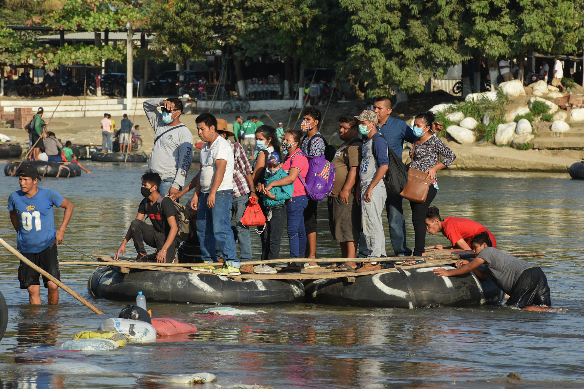 Peoples cross the Suchiate River on a raft from Guatemala to Ciudad Hidalgo, Mexico on January 18, 2021, as a new migrant caravan, mostly of Hondurans heading to the US is expected to arrive. (Photo by ISAAC GUZMAN / AFP)