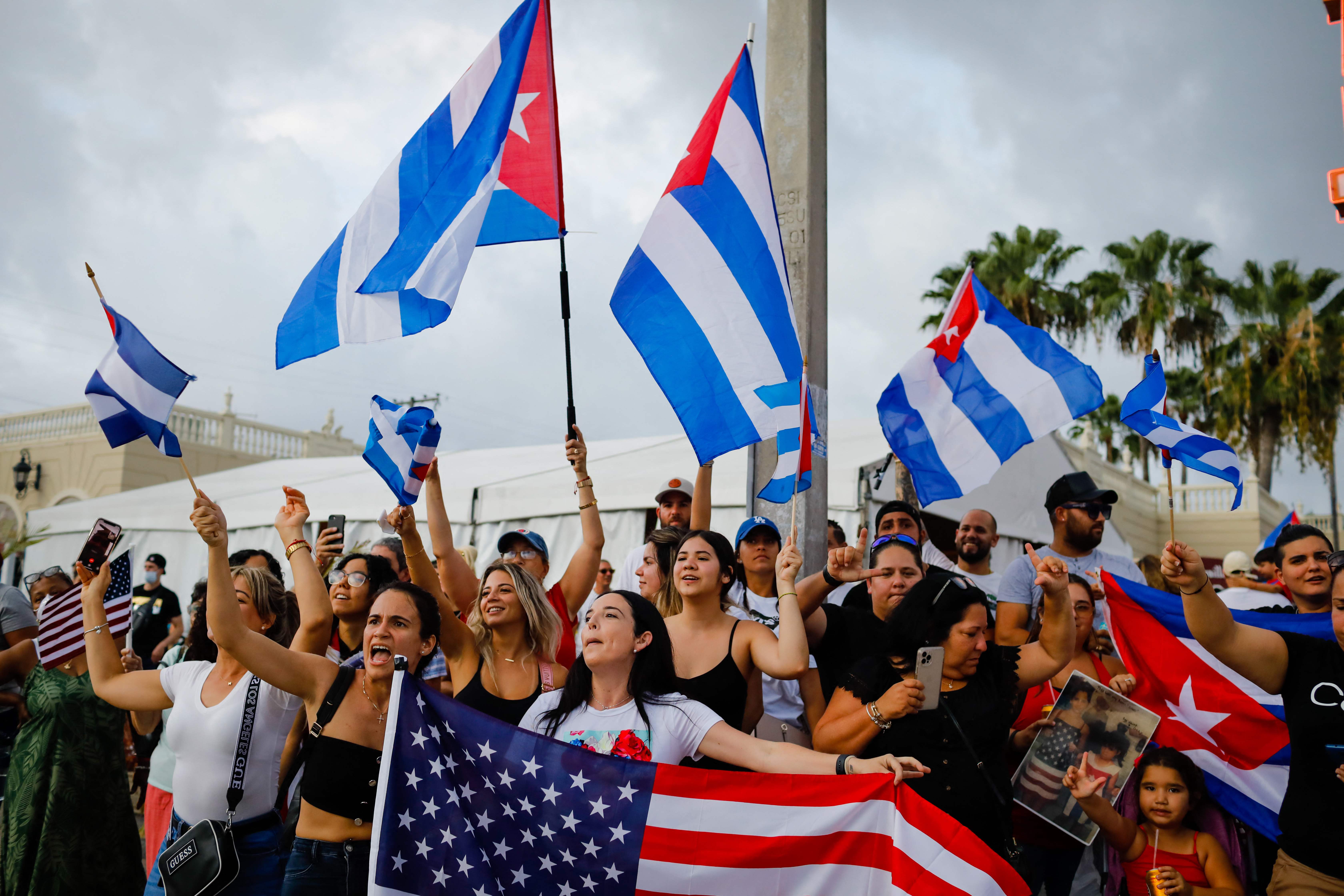 People demonstrate, some holding Cuban and US flags, during a protest against the Cuban government at Versailles Restaurant in Miami, on July 12, 2021. - Havana on Monday blamed a US "policy of economic suffocation" for unprecedented protests against Cuba's communist government as Washington pointed the finger at "decades of repression" in the one-party state. (Photo by Eva Marie UZCATEGUI / AFP)