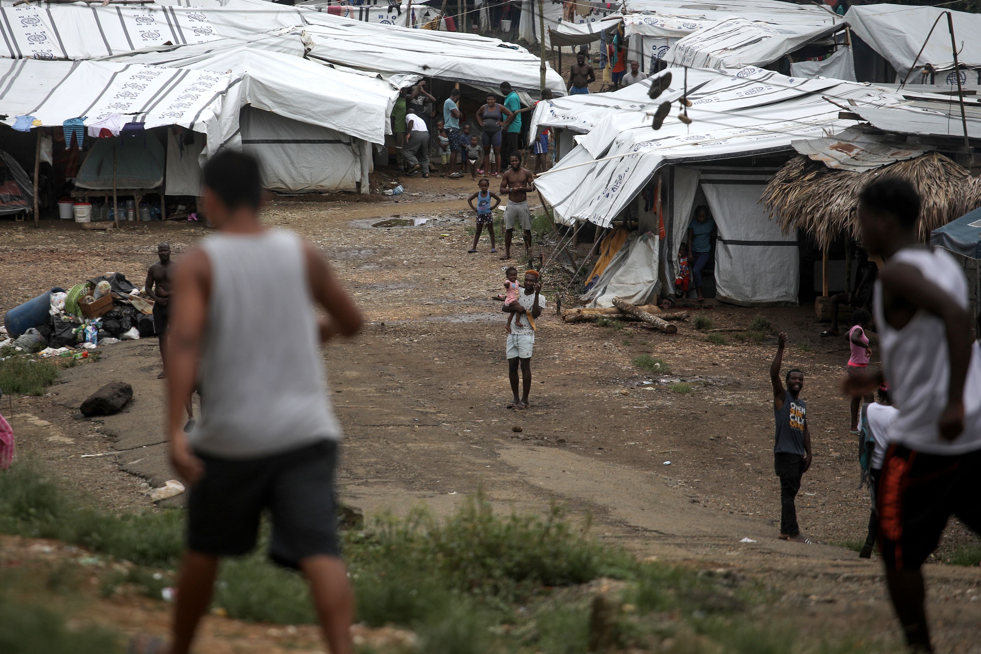 Migrants are seen near makeshift homes at a camp in La Penita, Darien province, Panama, August 6, 2020, where hundreds of migrants remain amid the COVID-19 coronavirus pandemic. - Thousands of migrants, mostly Haitians and Africans seeking to reach the US, remain in camps in the provinces of Darien and Chiriqui. (Photo by MAURICIO VALENZUELA / AFP)