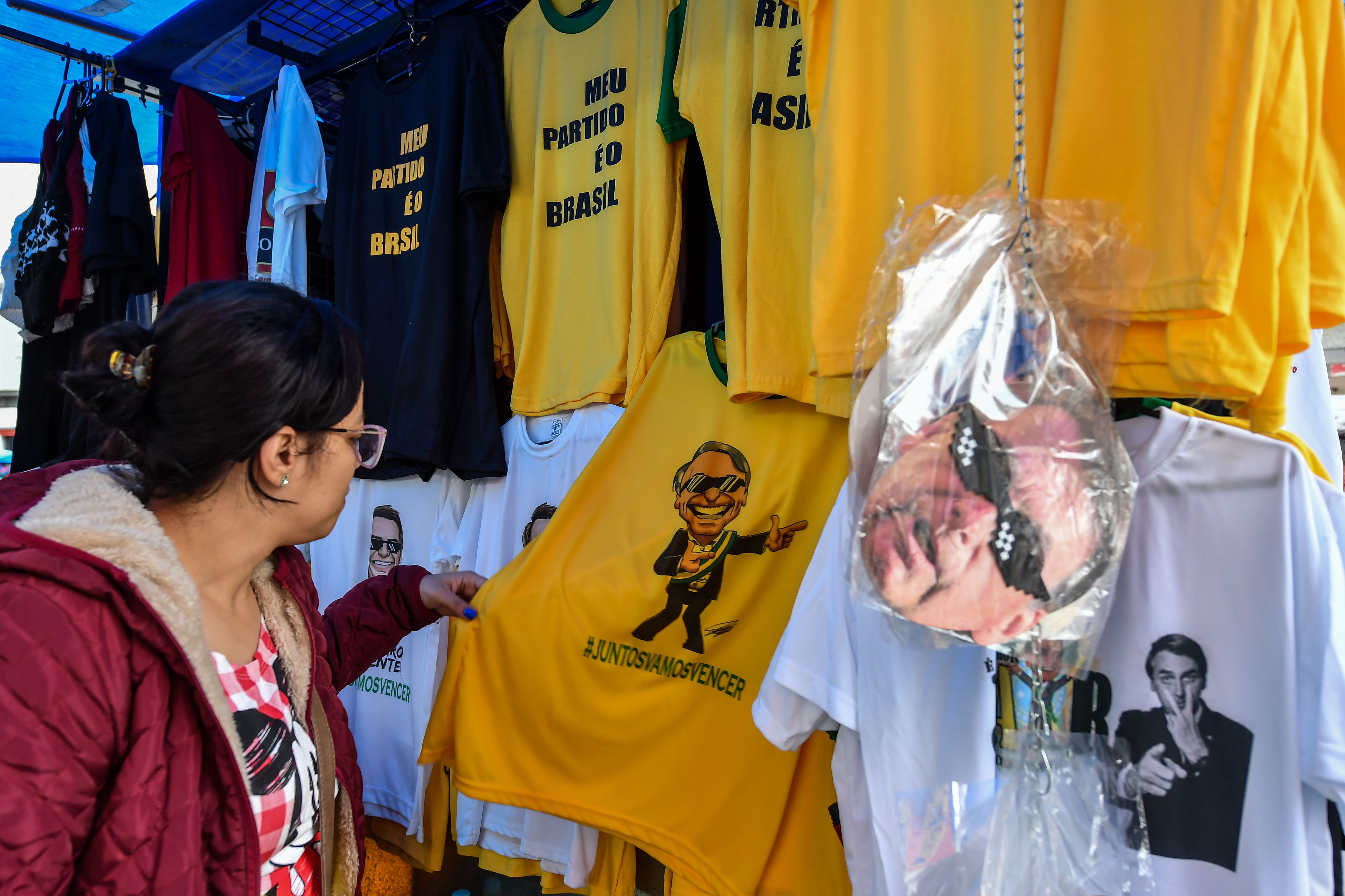 Una mujer observa una camiseta con una imagen del candidato presidencial para el Partido Social Liberal (PSL), Jair Bolsonaro, en una calle comercial en el centro de São Paulo, Brasil. Foto: AFP