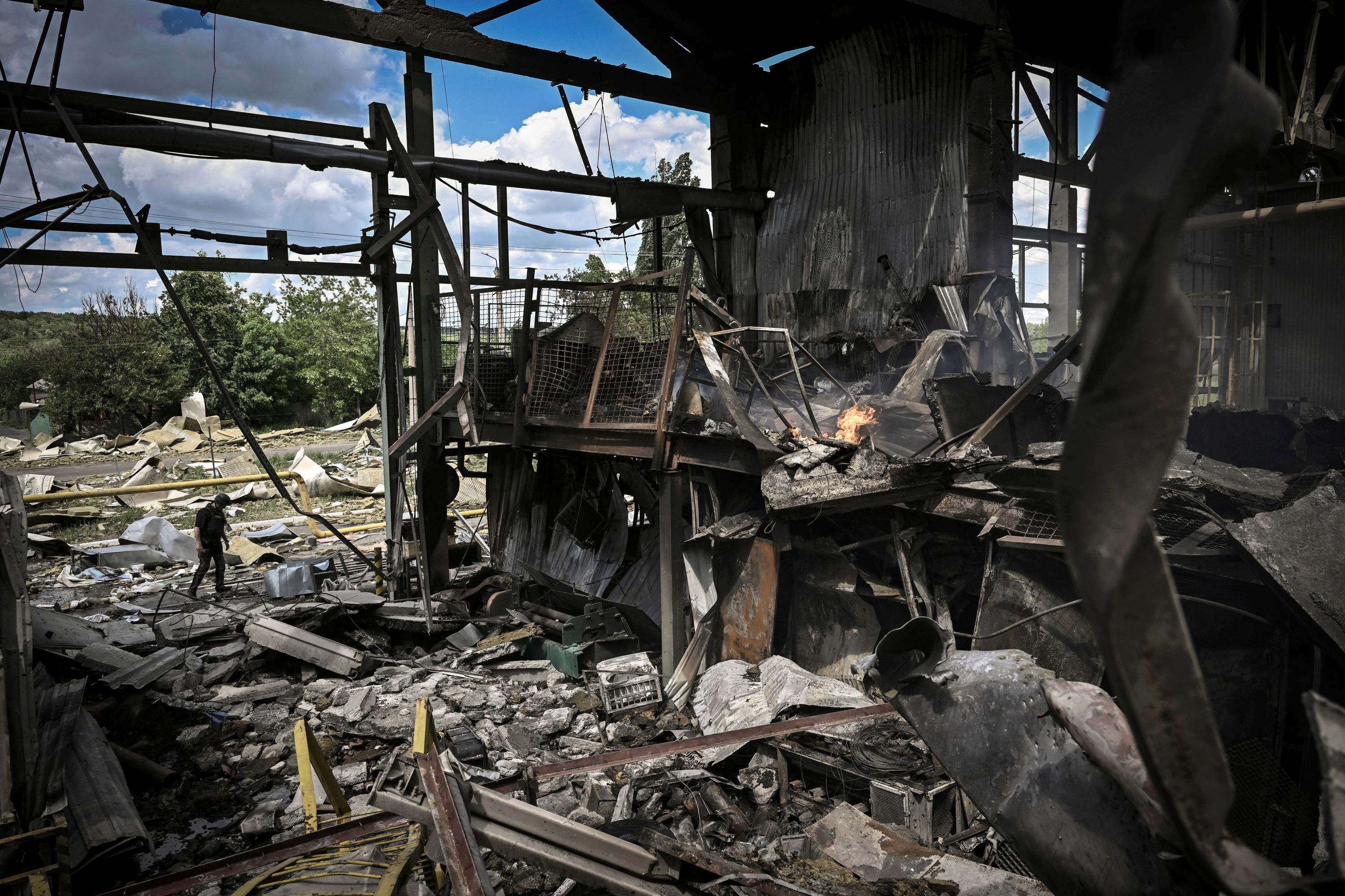 A man walks outside a Gypsum Manufactory plant after shelling in the city of Bakhmut at the eastern Ukrainian region of Donbas on May 27, 2022, on the 93rd day of the Russian invasion of Ukraine. - Russia on May 27, 2022 pressed its deadly offensive to capture key points in the eastern Donbas region of Ukraine, with more bombing of residential areas and pro-Moscow forces claiming the capture of a key town on the way to Kyiv-controlled territory. (Photo by Aris Messinis / AFP)