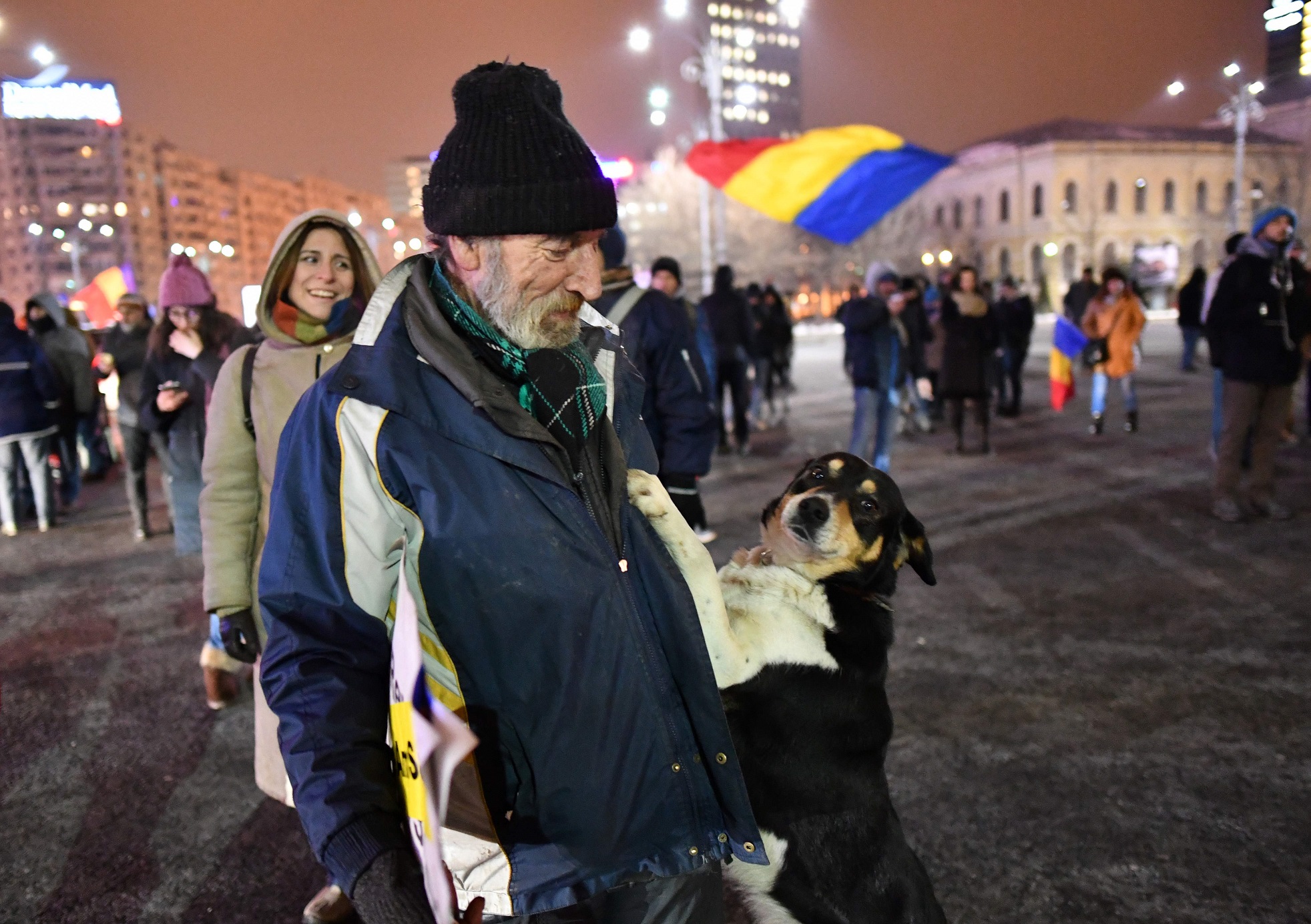 Este hombre se hizo acompañar por su perro durante una protesta, el 13 de febrero en Bucarest, contra un proyecto de ley que pretendía relajar las penas por corrupción.