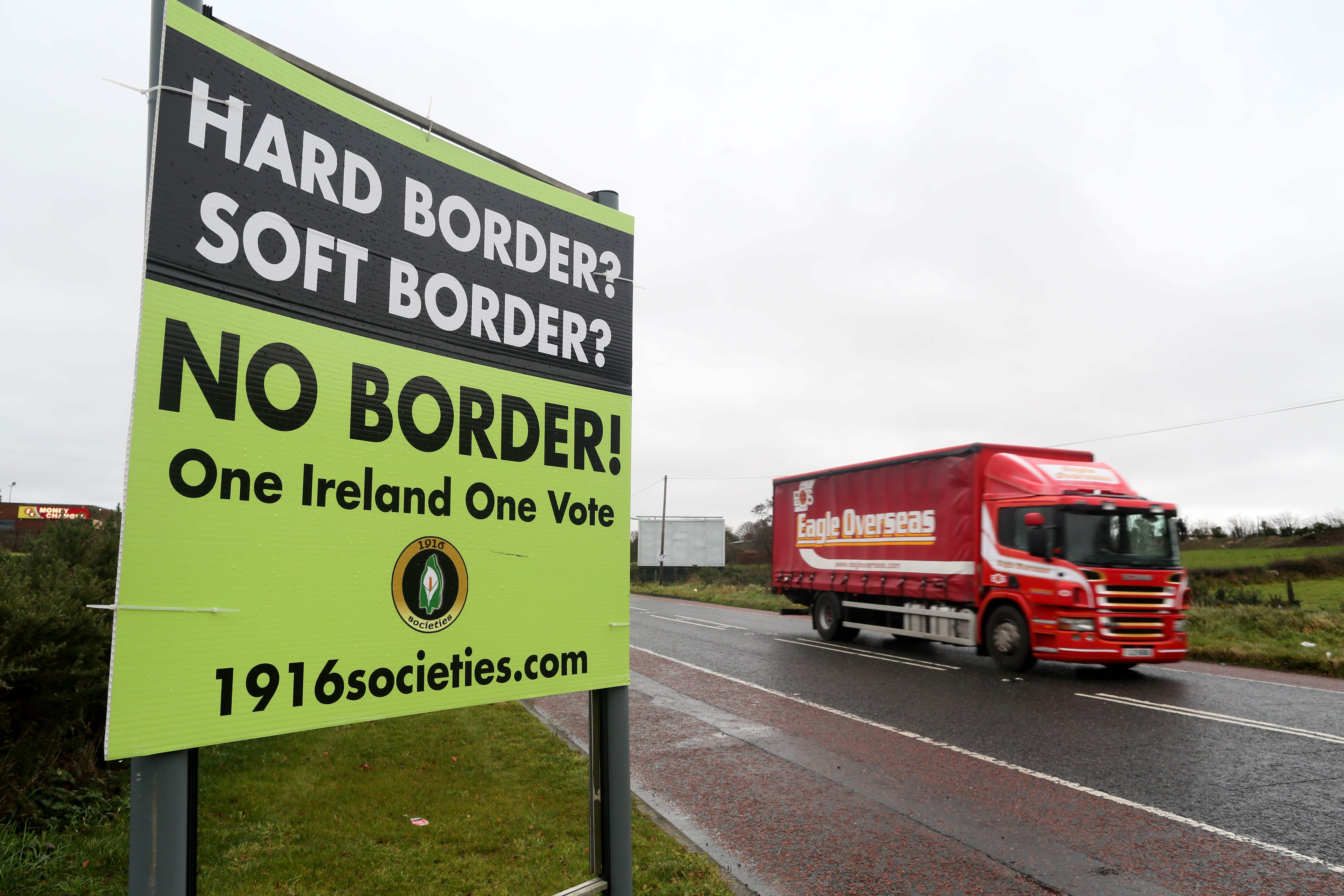 A lorry passes a sign calling for no border to be imposed between Ireland and Northern Ireland outside Newry, Northern Ireland, on November 14, 2018 near the Irish border. - British Prime Minister Theresa May defended her anguished divorce deal with the European Union before rowdy lawmakers on Wednesday before trying to win the backing of her splintered cabinet with the so-called "Irish backstop" arrangement to guard against the imposition of a hard border between Ireland and Northern Ireland one of the contentious issues, according to reports. (Photo by Paul FAITH / AFP)