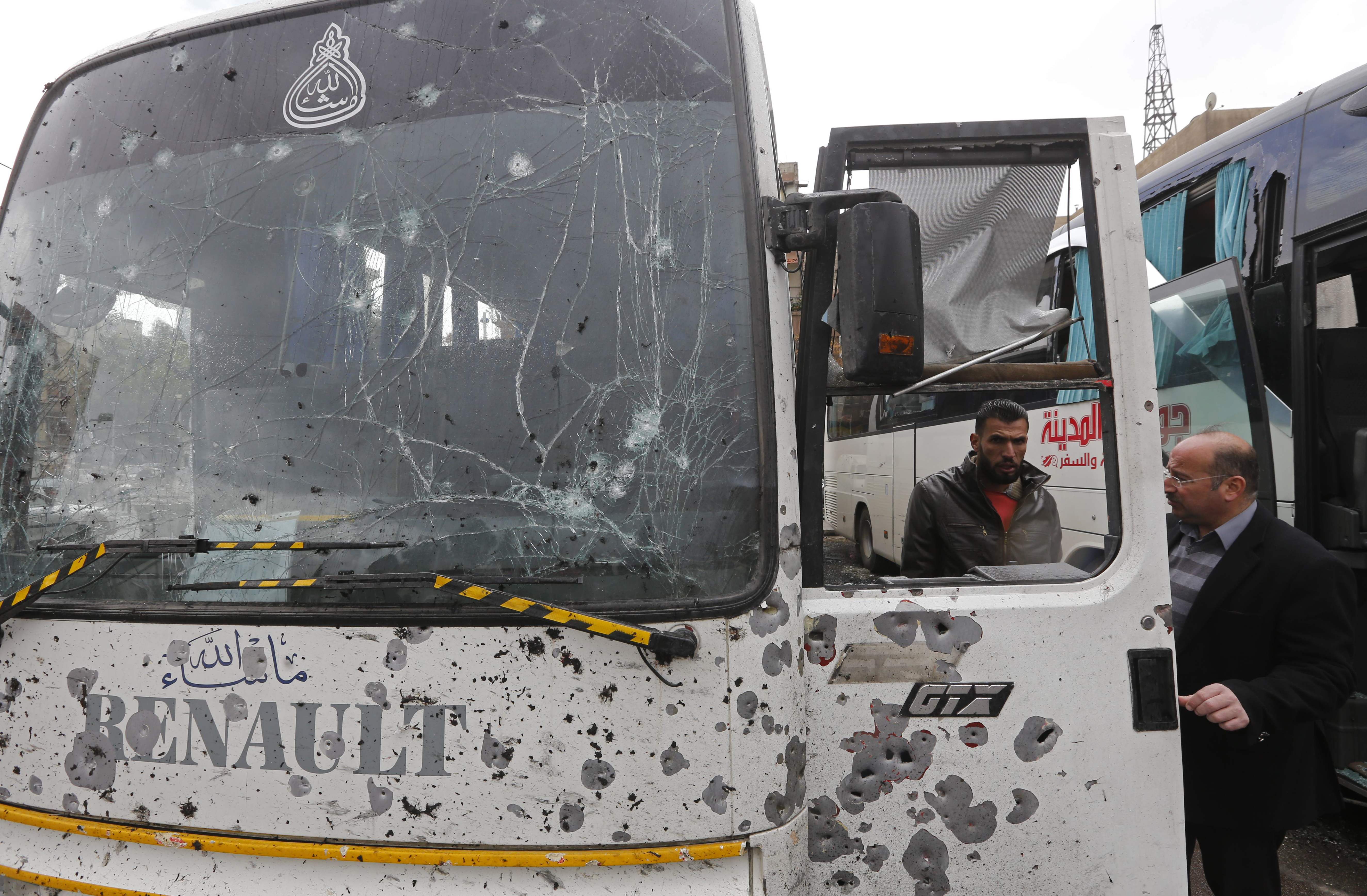 Las autoridades en Siria verifican el bus dañado en la escena del atentado en contra de peregrinos chiitas.