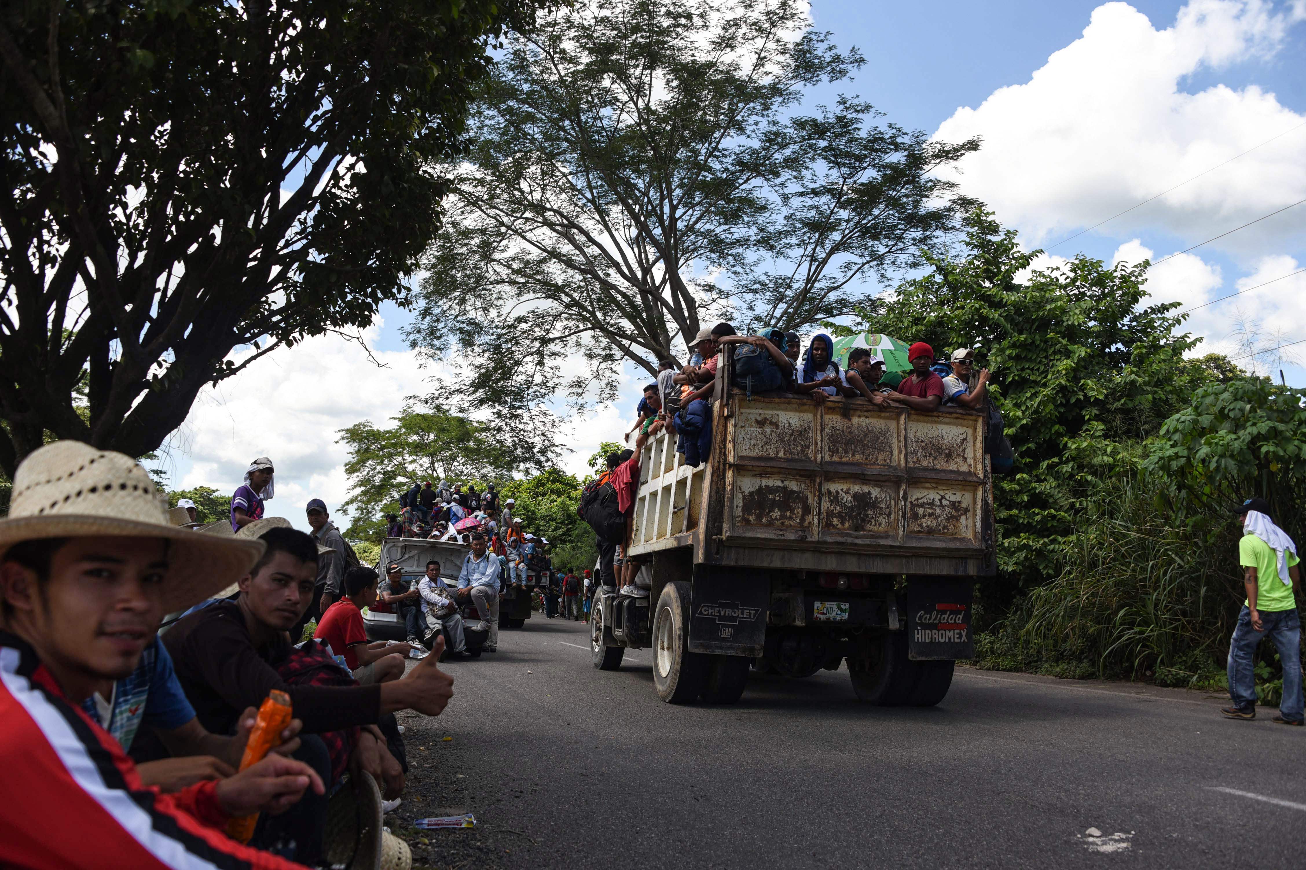 Honduran migrants onboard a truck take part in a caravan heading to the US, in the outskirts of Tapachula, on their way to Huixtla, Chiapas state, Mexico, on October 22, 2018. - President Donald Trump on Monday called the migrant caravan heading toward the US-Mexico border a national emergency, saying he has alerted the US border patrol and military. (Photo by Johan ORDONEZ / AFP)