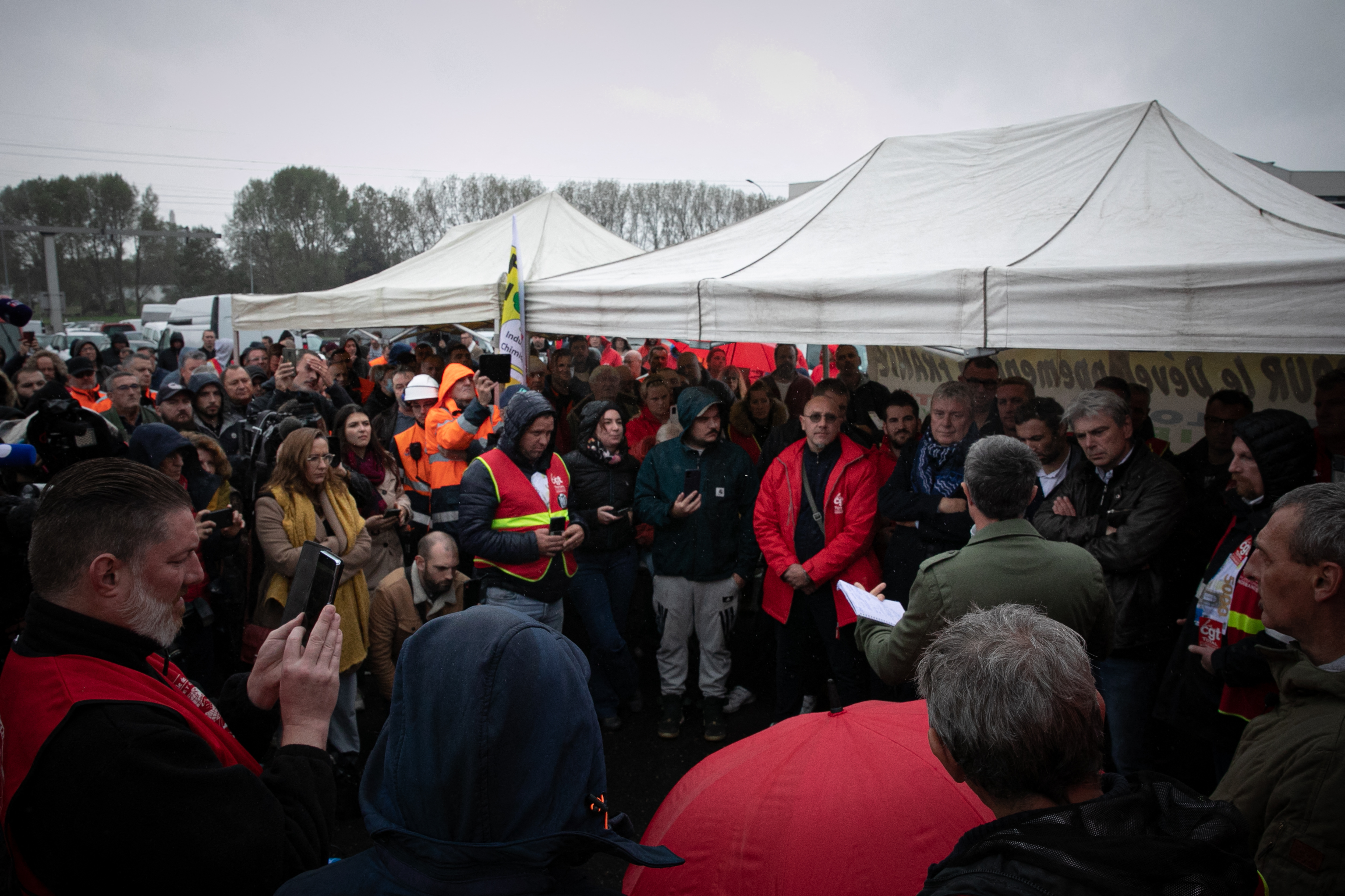 French left-wing coalition NUPES (New People's Ecologic and Social Union) and La France Insoumise (LFI) Member of Parliament Francois Ruffin (R) speaks to employees on strike at the TotalEnergies raffinery site, in Gonfreville-l'Orcher, near Le Havre, northwestern France, on October 13, 2022. - TotalEnergies has eased up on salaries by announcing on October 13, 2022 an exceptional bonus equivalent to one month's salary for its employees worldwide, coupled with a proposed 6% increase in 2023 for French employees who have been on strike for 17 days in the refineries under threat of government requisition. The industrial action to demand pay hikes has paralysed six out of the seven fuel refineries in France, leading to shortages of petrol and diesel exacerbated by panic-buying from drivers. (Photo by Lou BENOIST / AFP)