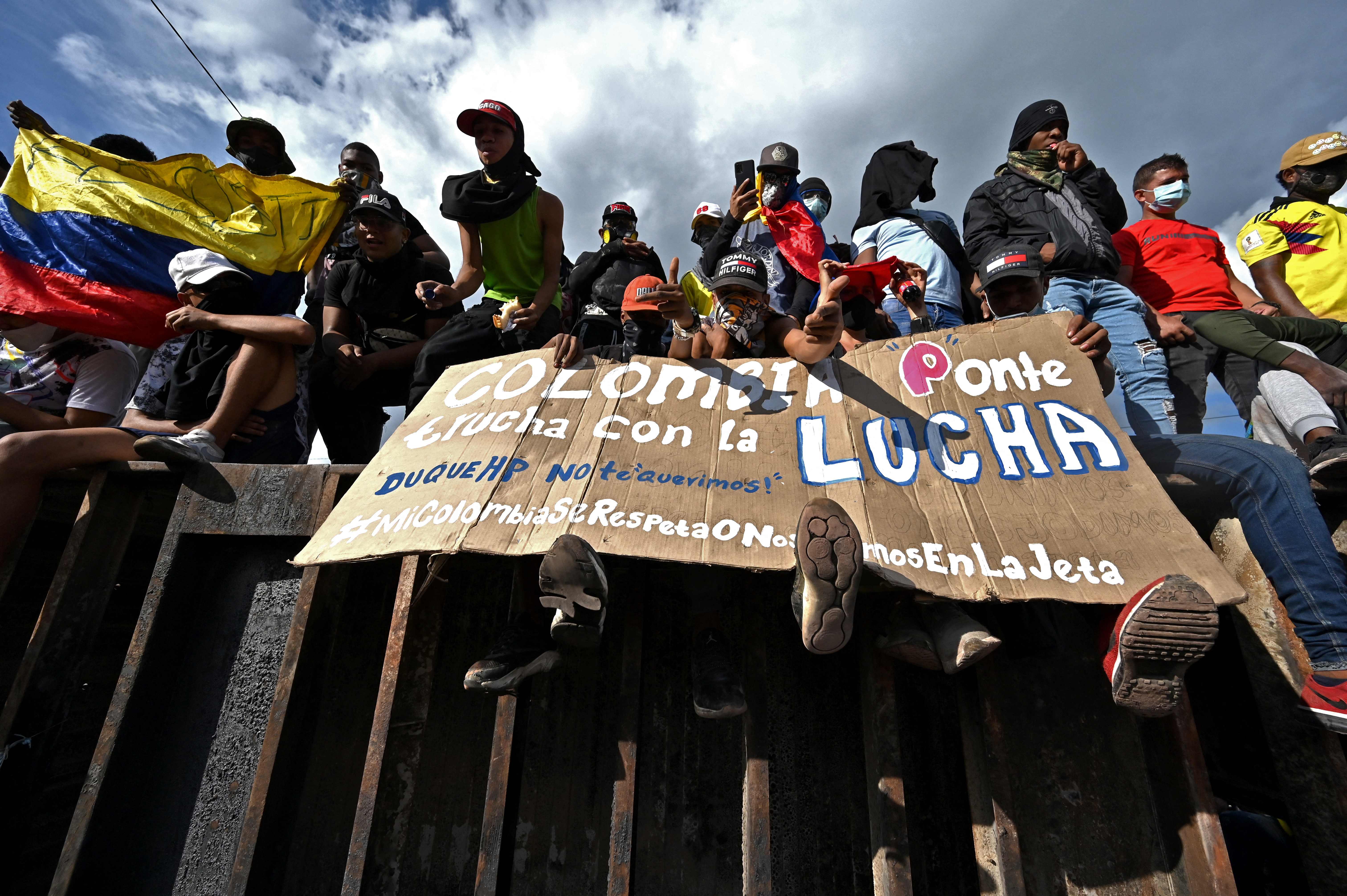 People protest against a tax reform bill they say will leave them poorer as the country battles its deadliest phase yet of the coronavirus pandemic, in Cali, Colombia, on May 1, 2021. - Colombian President Ivan Duque caved in on April 30 to widespread anger and said he would overhaul the proposed tax reform. Duque announced he was shelving clauses that would lower the income tax threshold to broaden the tax base and raise value-added taxes on goods and services. (Photo by Luis ROBAYO / AFP)