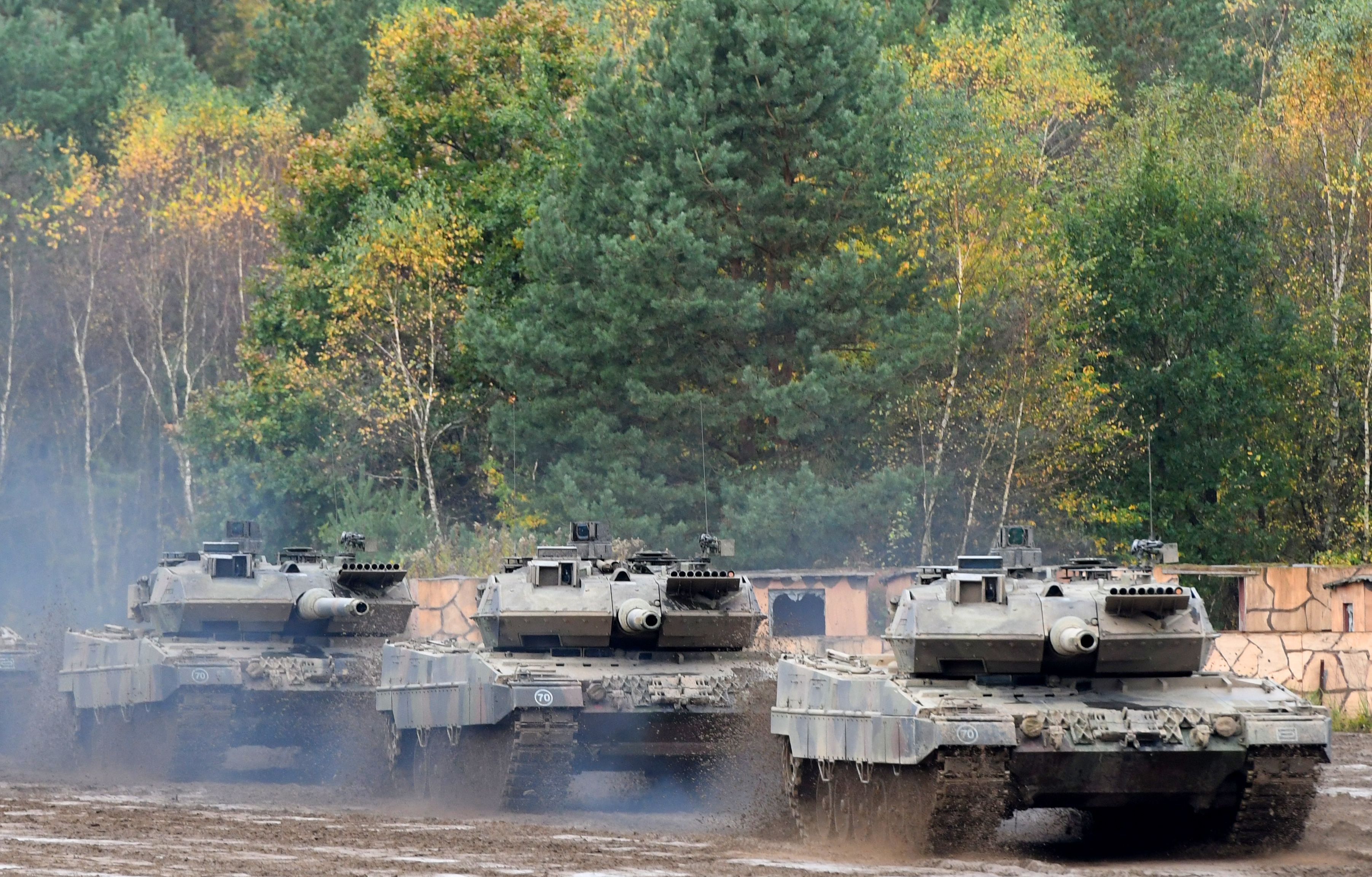 (FILES) This file photo taken on October 13, 2017 shows an armored unit with Leopard 2 A7 main battle tanks of the German armed forces Bundeswehr driving through the mud in the context of an informative educational practice "Land Operation Exercise 2017" at the military training area in Munster, northern Germany. - NATO countries are set to announce new "heavier weapons" for Ukraine, the alliance's chief said on January 18, 2023, as Ukrainian President Volodymyr Zelensky called on his backers to speed up their decision-making. US Secretary of Defence Lloyd Austin will convene a meeting of around 50 countries on January 20, 2023 at the US-run Ramstein military base in Germany, including all 30 members of the NATO alliance. The German-made Leopard 2 is seen as one of the best-performing models worldwide and is widely used across Europe, meaning spare parts and ammunition could be easily sourced. (Photo by PATRIK STOLLARZ / AFP)
