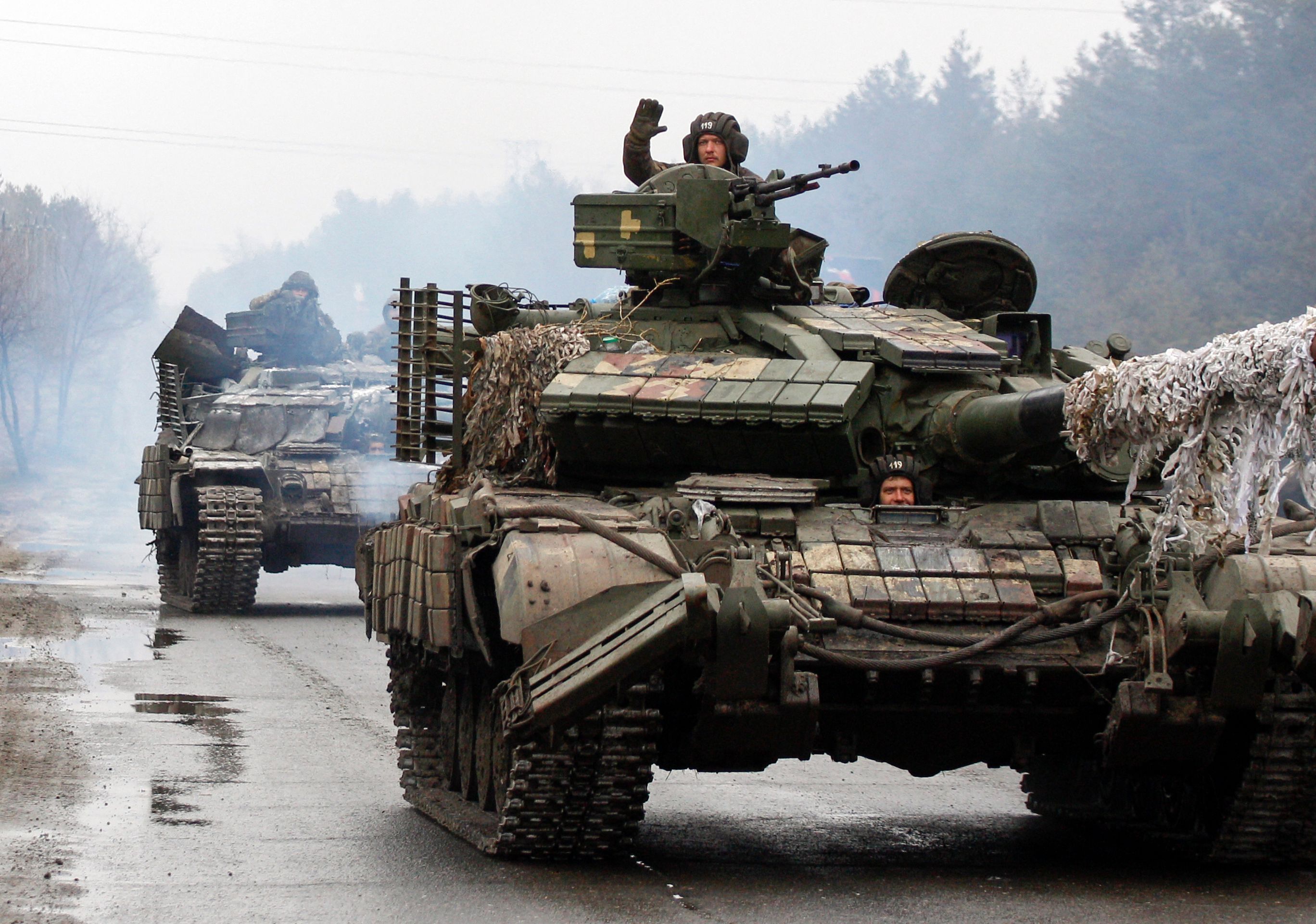 Ukrainian servicemen ride on tanks towards the front line with Russian forces in the Lugansk region of Ukraine on February 25, 2022. - Ukrainian forces fought off Russian troops in the capital Kyiv on the second day of a conflict that has claimed dozens of lives, as the EU approved sanctions targeting President Vladimir Putin. Small arms fire and explosions were heard in the city's northern district of Obolonsky as what appeared to be an advance party of Russia's invasion force left a trail of destruction. (Photo by Anatolii STEPANOV / AFP)