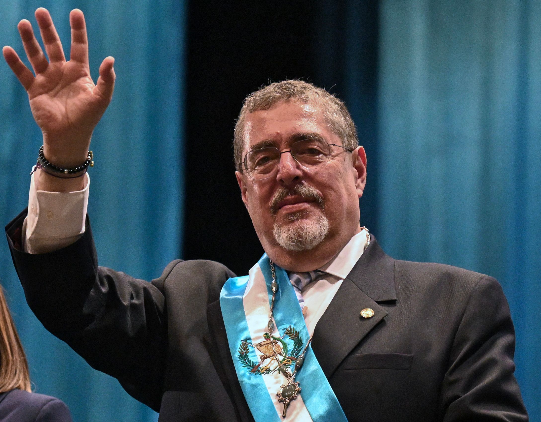 Guatemala's new President Bernardo Arevalo waves after swearing in during his inauguration ceremony at the Miguel Angel Asturias Cultural Centre in Guatemala City, on January 14, 2024. Bernardo Arevalo was finally sworn in as Guatemala's president on Sunday after the ceremony was delayed for more than nine hours, capping months of judicial machinations to block the anti-corruption crusader from taking office. (Photo by JOHAN ORDONEZ / AFP)
