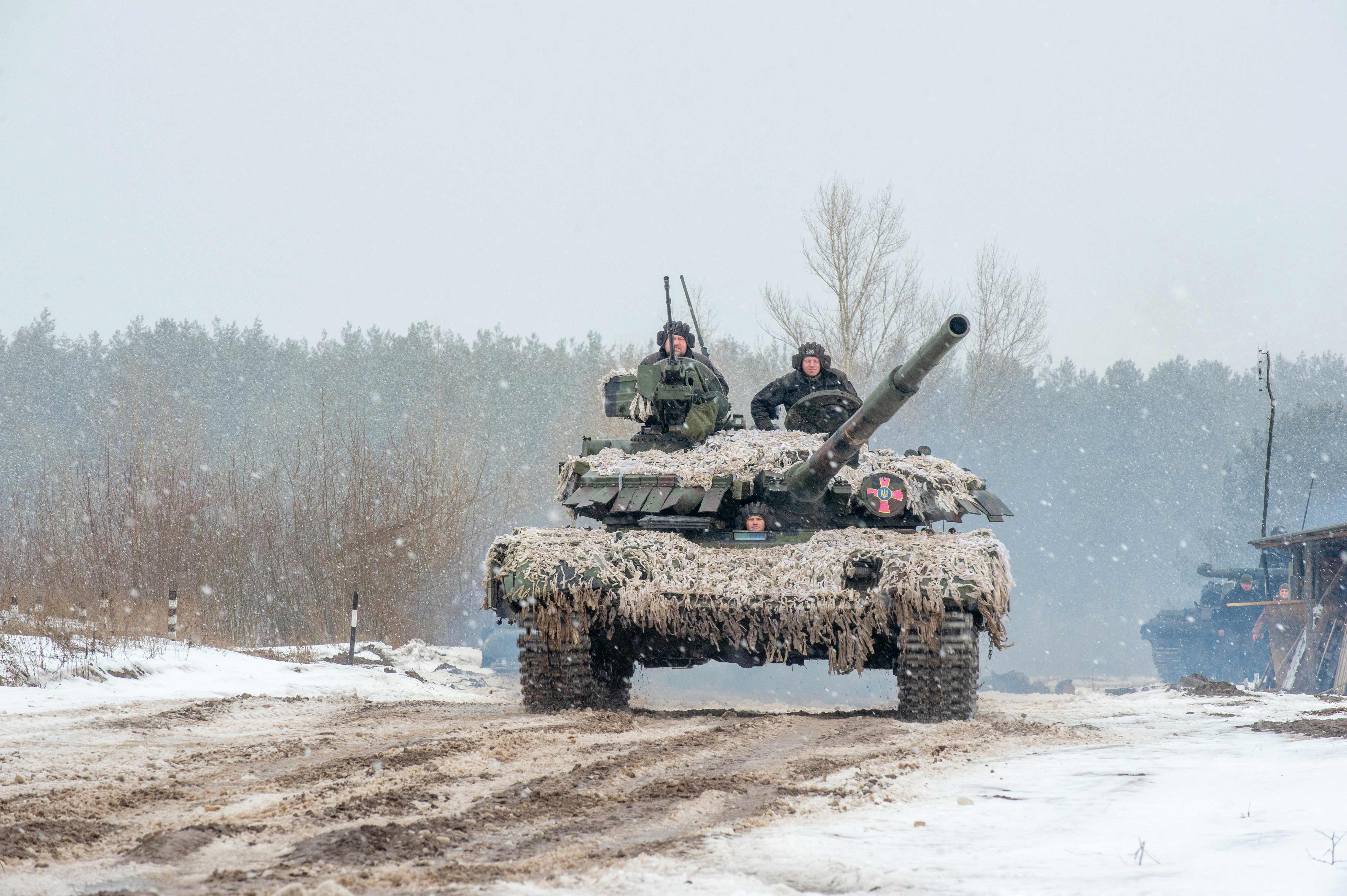 TOPSHOT - Ukrainian Military Forces servicemen of the 92nd mechanized brigade use tanks, self-propelled guns and other armored vehicles to conduct live-fire exercises near the town of Chuguev, in Kharkiv region, on February 10, 2022. - Russia's deployment for a military exercise in Belarus and on the borders of Ukraine marks a "dangerous moment" for European security, NATO's chief said on February 10, 2022. (Photo by Sergey BOBOK / AFP)