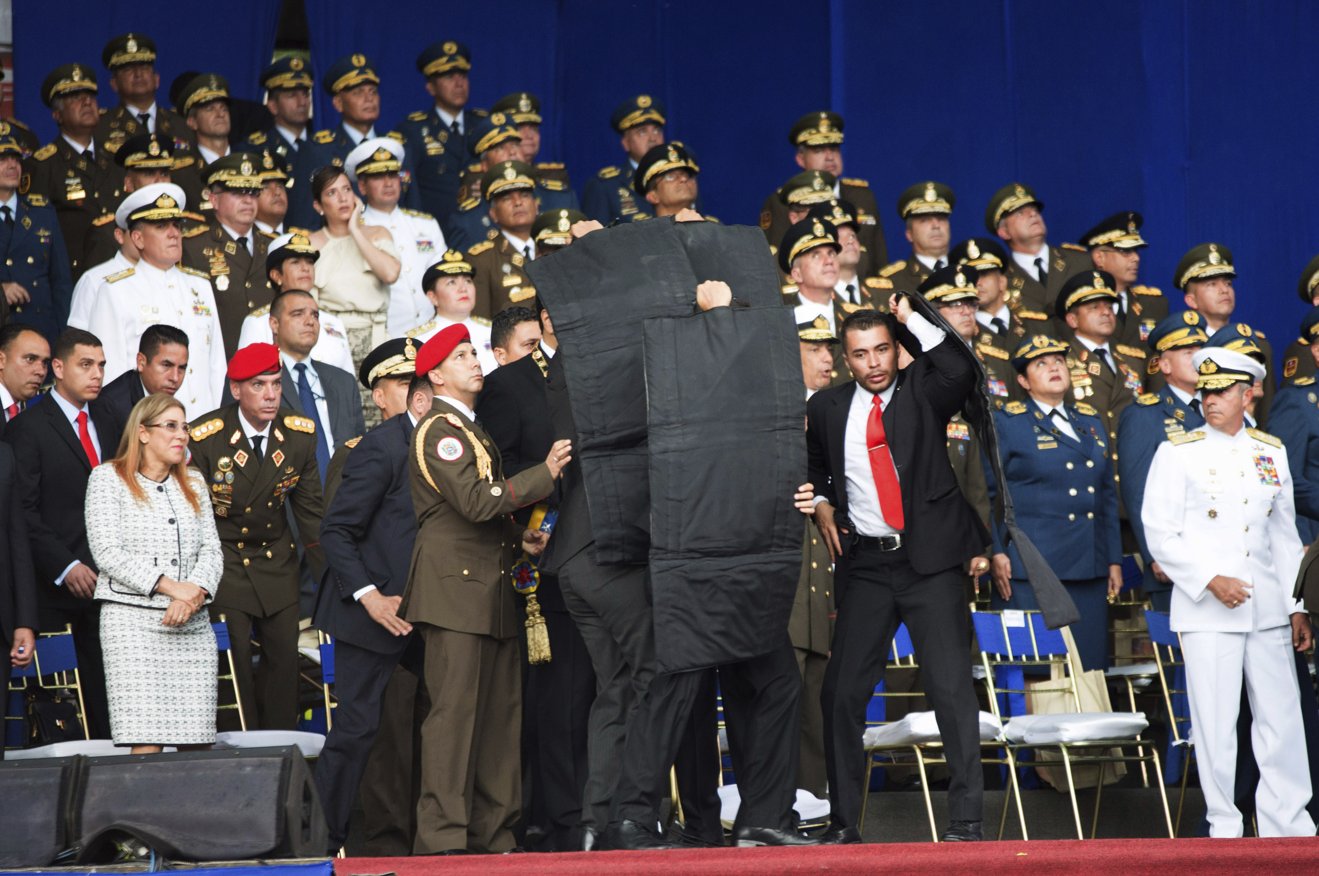 Personal de seguridad del presidente Nicolás Maduro lo protege en el momento en el que se llevaron a cabo las explosiones, en Caracas. Foto: Xinhua/AP