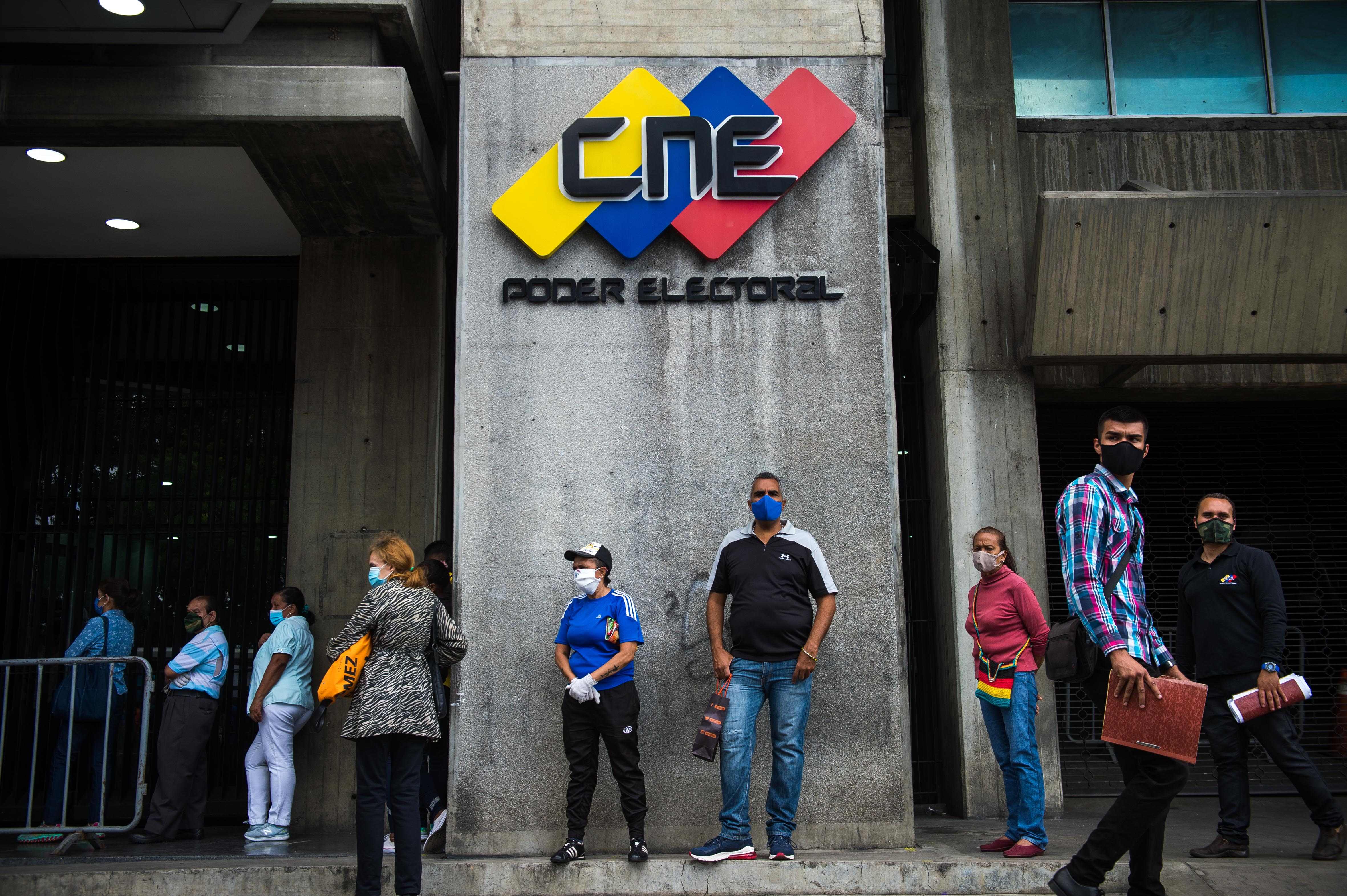 People queue at the National Electoral Council (CNE) headquarters in Caracas, on December 2, 2020 ahead of the weekend's parliamentary election. - Venezuelan will hold legislative elections on December 6. (Photo by Cristian HERNANDEZ / AFP)