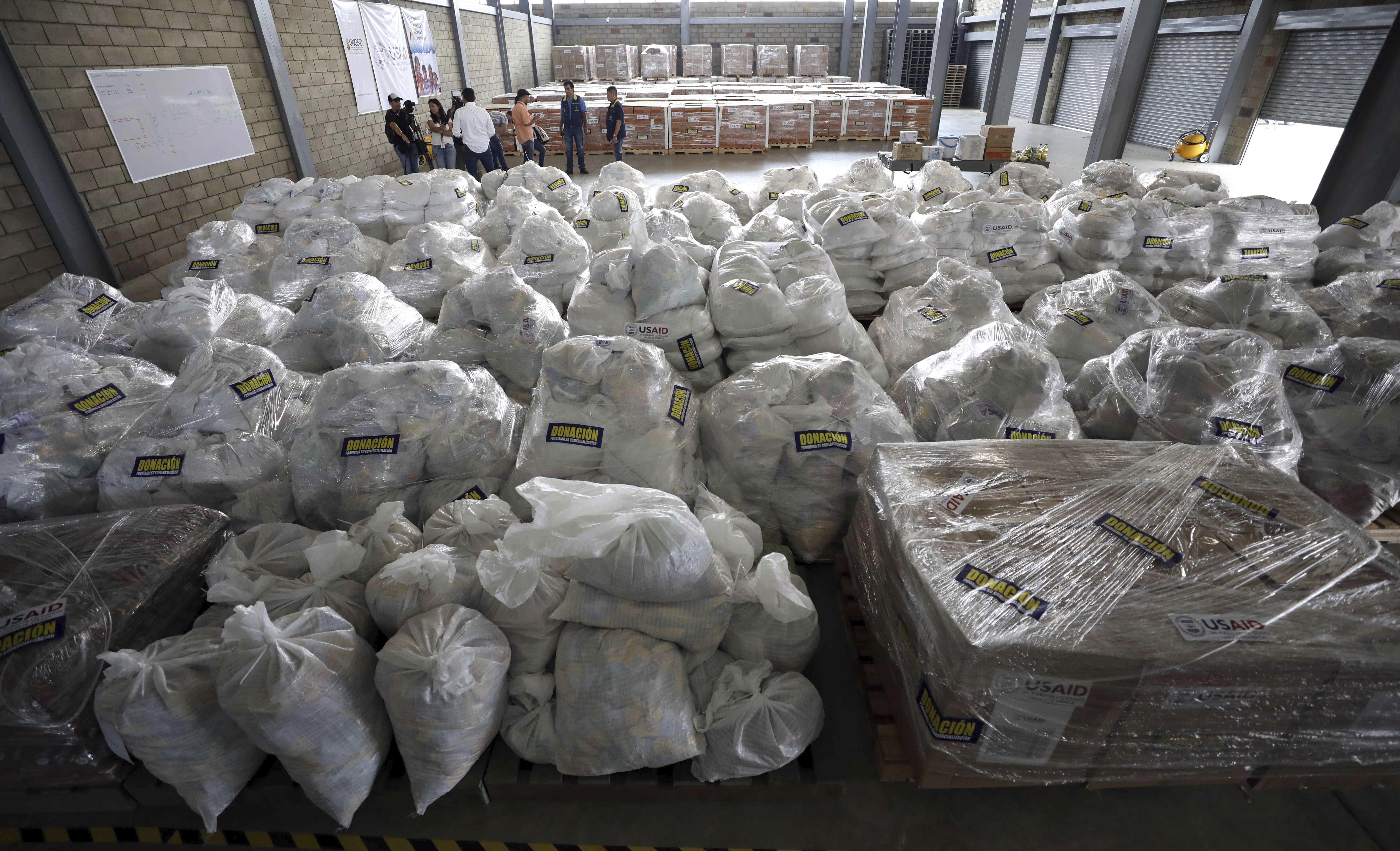 Journalists and members of Colombia's government tour a warehouse where USAID humanitarian aid is stored near the Tienditas International Bridge on the outskirts of Cucuta, Colombia, on the border with Venezuela, Tuesday, Feb. 19, 2019. The U.S. military airlifted tons of humanitarian aid as part of an effort meant to undermine socialist President Nicolas Maduro and back his rival for the leadership of the South American nation. (AP Photo/Fernando Vergara)