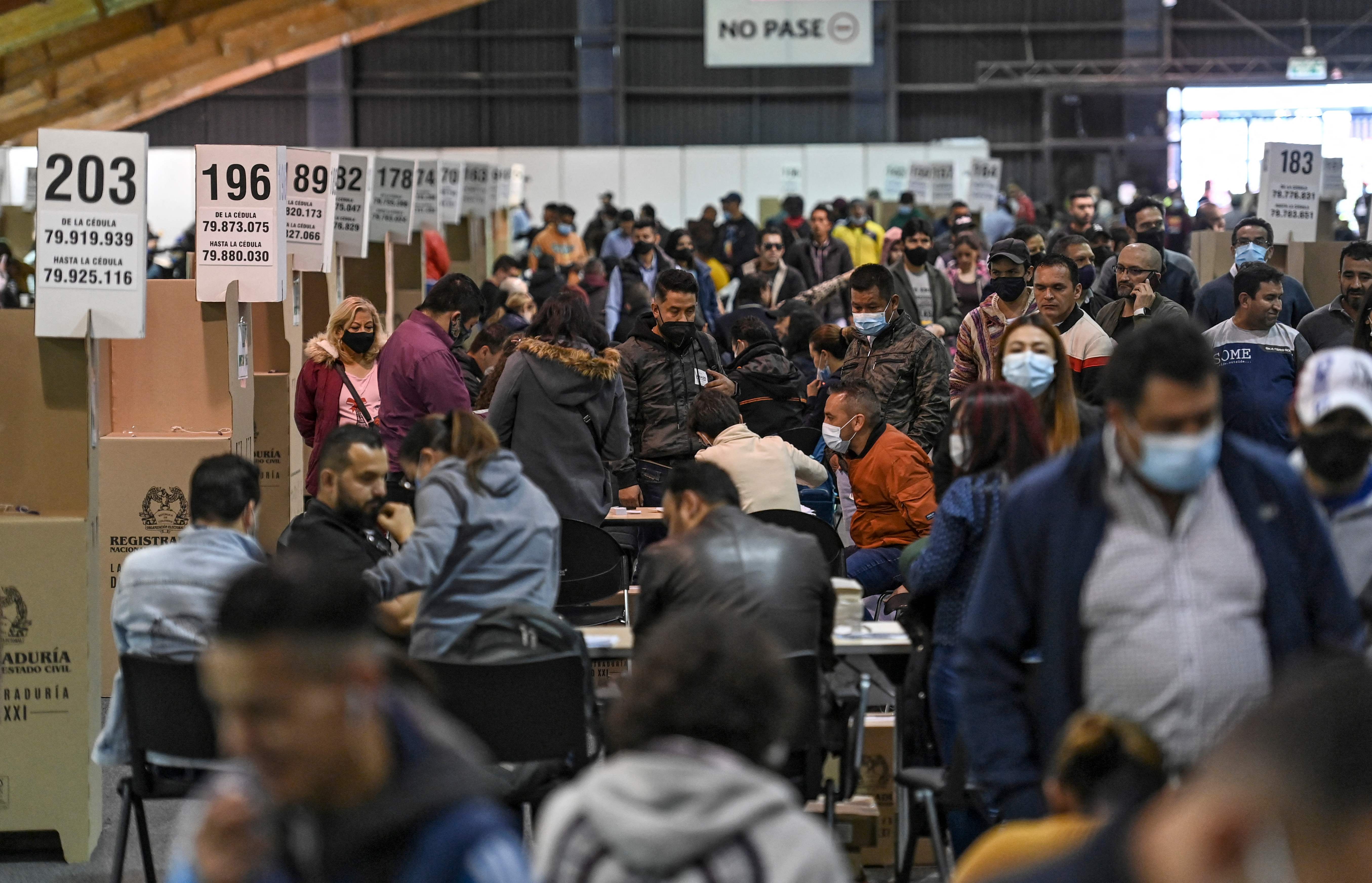 People vote at a polling station in Bogota during the Colombian presidential election, on May 29, 2022. - Colombians started voting Sunday in a first round of presidential elections, with a leftist poised for victory for the first time in the country's troubled history. (Photo by Juan BARRETO / AFP)