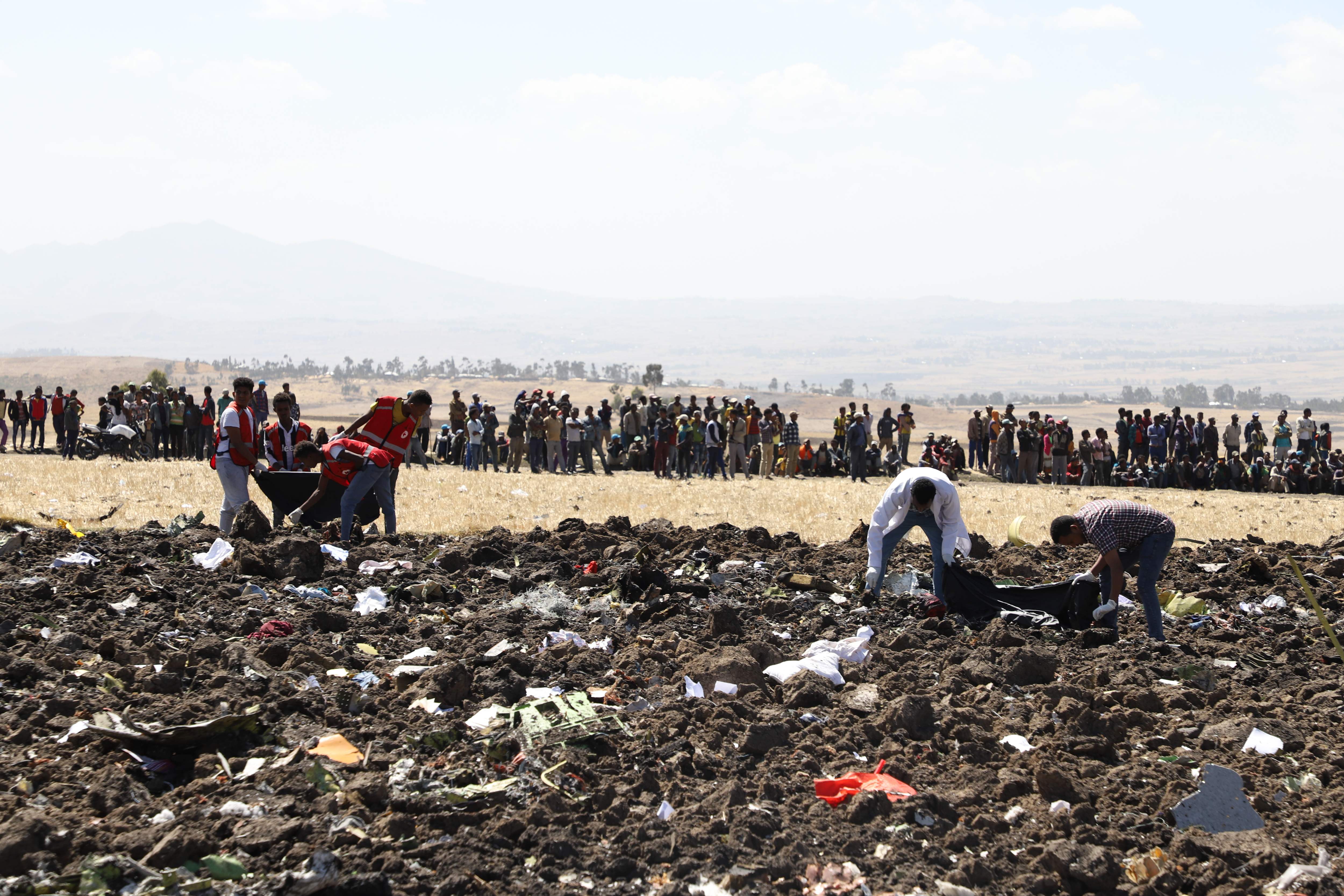 Rescue team collect remains of bodies amid debris at the crash site of Ethiopia Airlines near Bishoftu, a town some 60 kilometres southeast of Addis Ababa, Ethiopia, on March 10, 2019. - An Ethiopian Airlines Boeing 737 crashed on March 10 morning en route from Addis Ababa to Nairobi with 149 passengers and eight crew believed to be on board, Ethiopian Airlines said. (Photo by Michael TEWELDE / AFP)