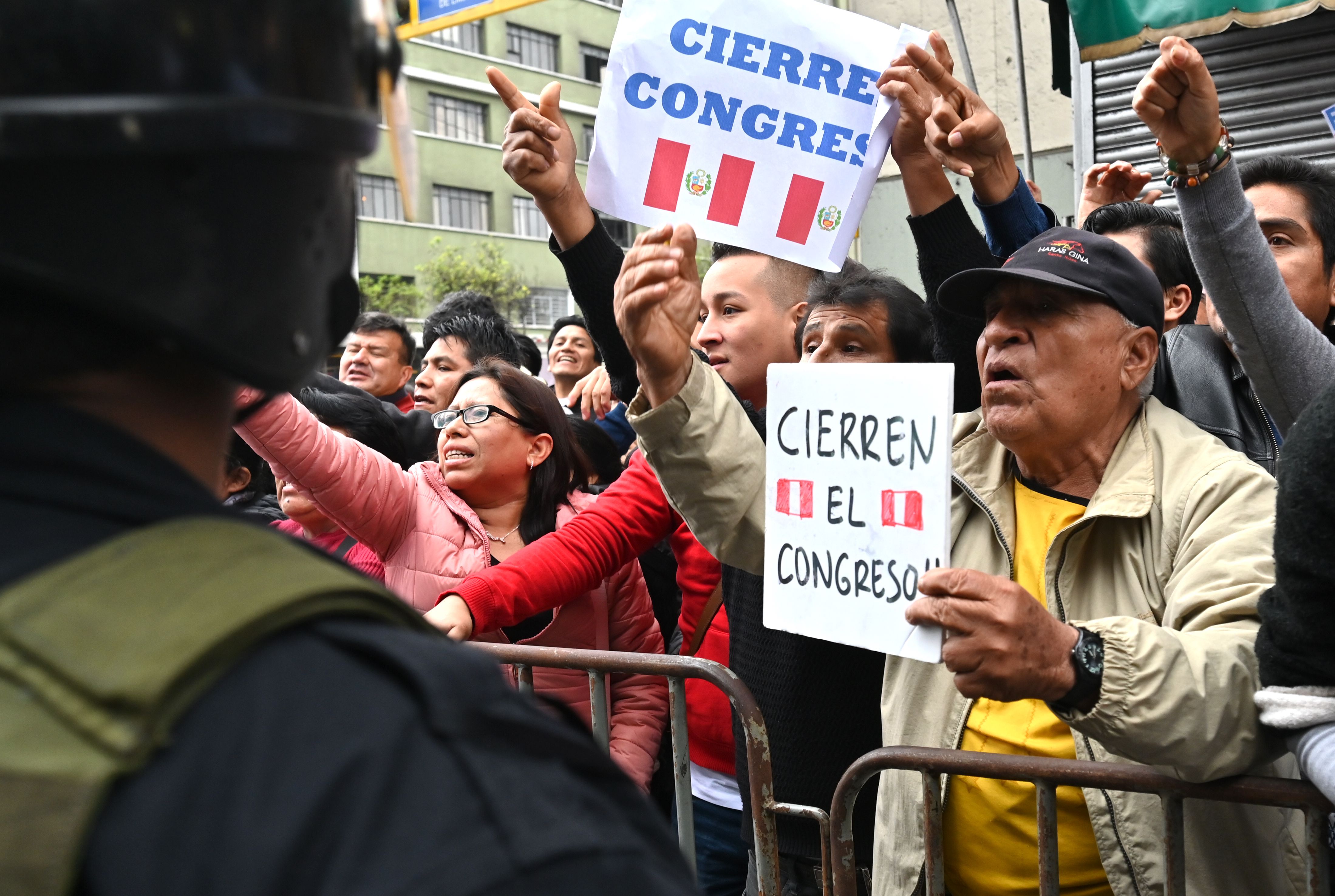 Protesters demand the dissolution of the Congress and demonstrate against lawmakers in Lima on September 30, 2019 after President Martin Vizcarra launches an ultimatum to Congress that he would dissolve it if he is denied a vote of confidence to reform the way in which the magistrates of the Constitutional Court are appointed. - Vizcarra had originally threatened to dissolve Congress and force new legislative elections in June, unless lawmakers backed his anti-graft proposals. The proposal to lift legislative immunity turned into the source of the latest conflict between Peru's executive and legislative branches; Vizcarra proposed giving the Supreme Court power to decide whether to strip a legislator of the protection. Congress, which currently holds the power to lift judicial immunity, rejected the idea. (Photo by Cris BOURONCLE / AFP)