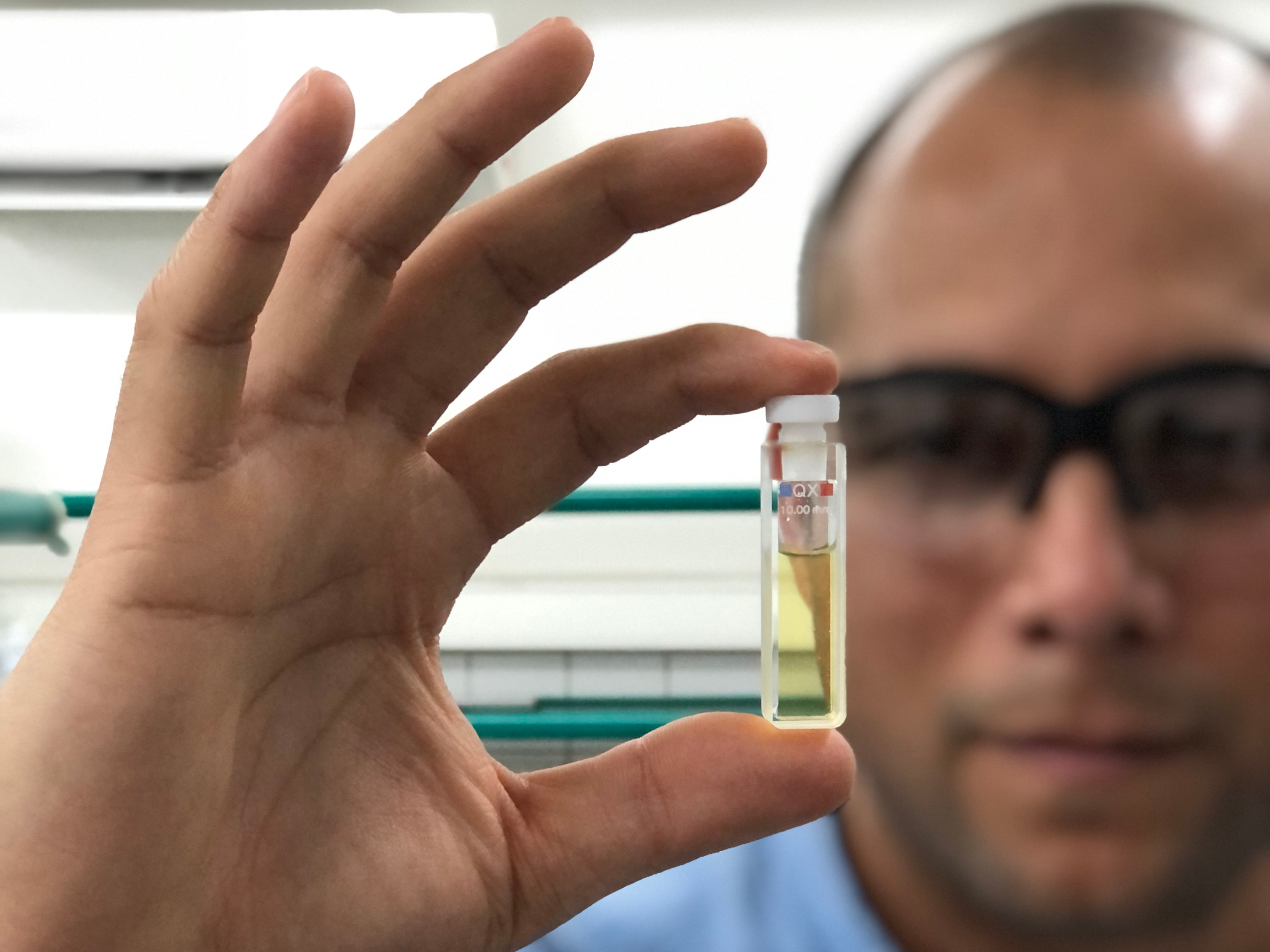 Bryan Calderón, coordinador de la investigación, sostiene un tubo con las nanopartículas.