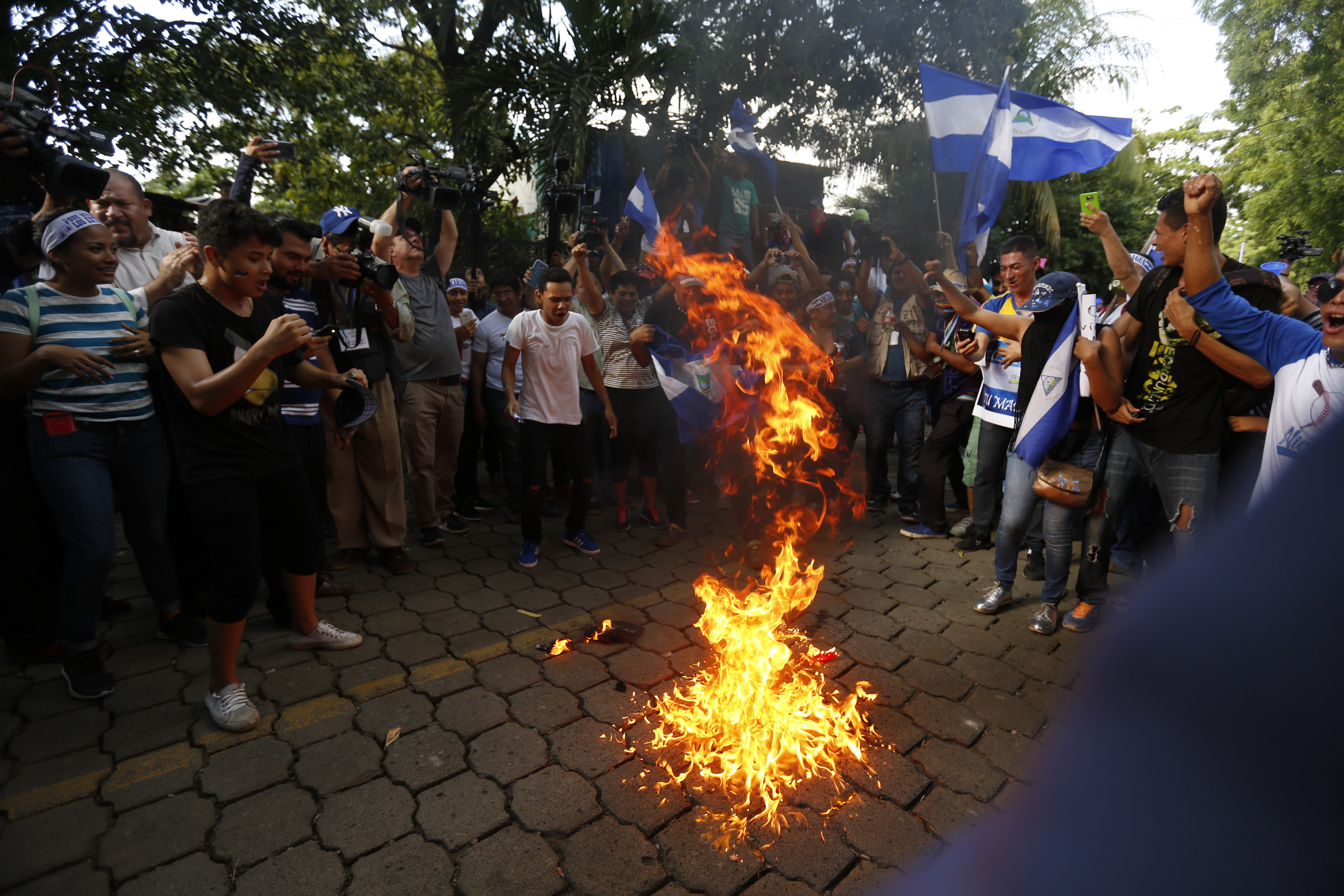 Decenas de manifestantes quemaron una bandera del Frente Sandinista durante una protesta, el viernes, en Managua, Nicaragua. Foto: AP