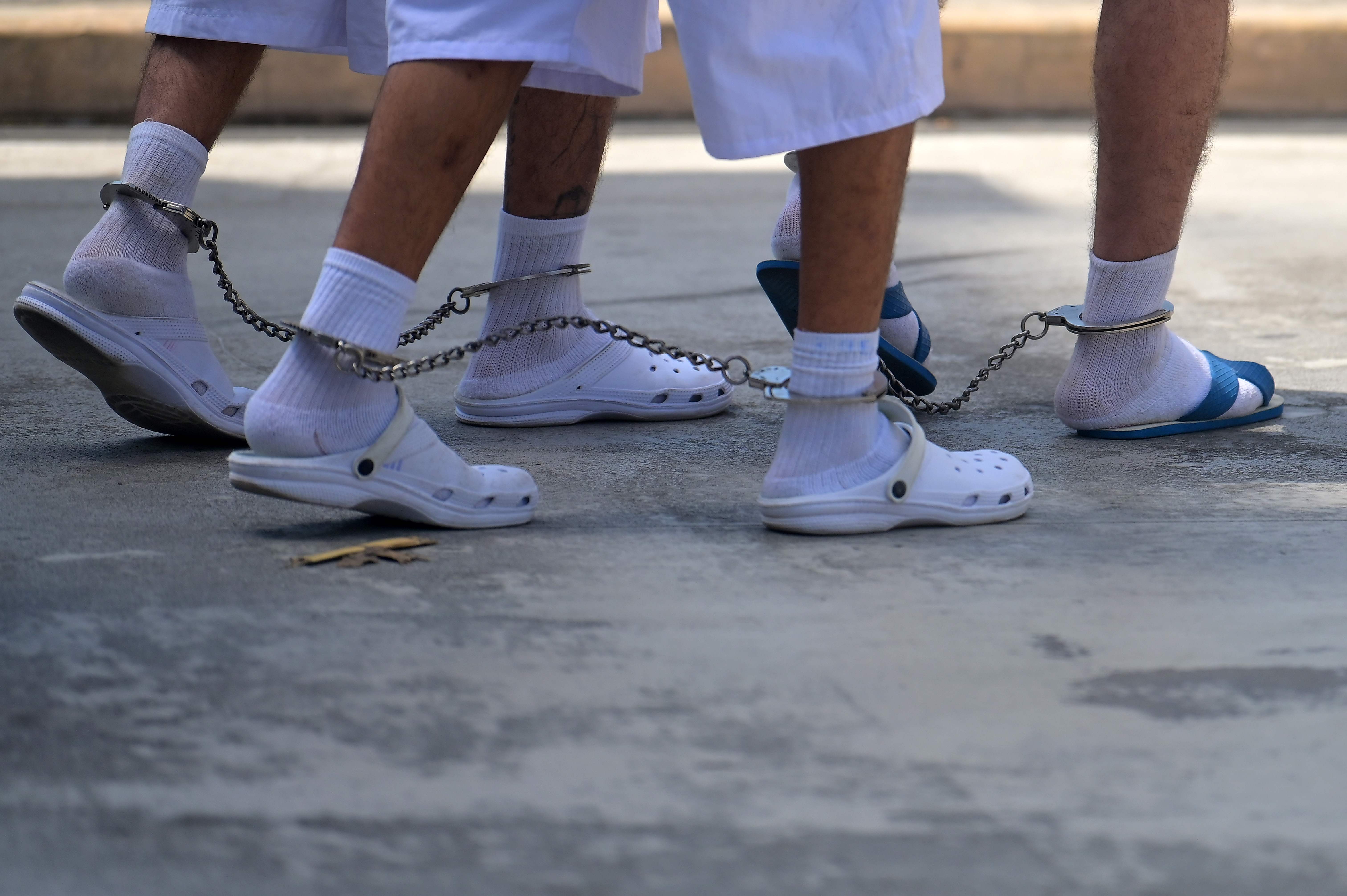 Suspected members of the Mara 18 who remain under custody, walk at Isidro Menendez Justice Court in San Salvador, on February 06, 2020. - Violent gangs operating in El Salvador are in retreat due to police and military operations, and the number of homicides and confrontations committed by their members has decreased, analysts said. (Photo by MARVIN RECINOS / AFP)