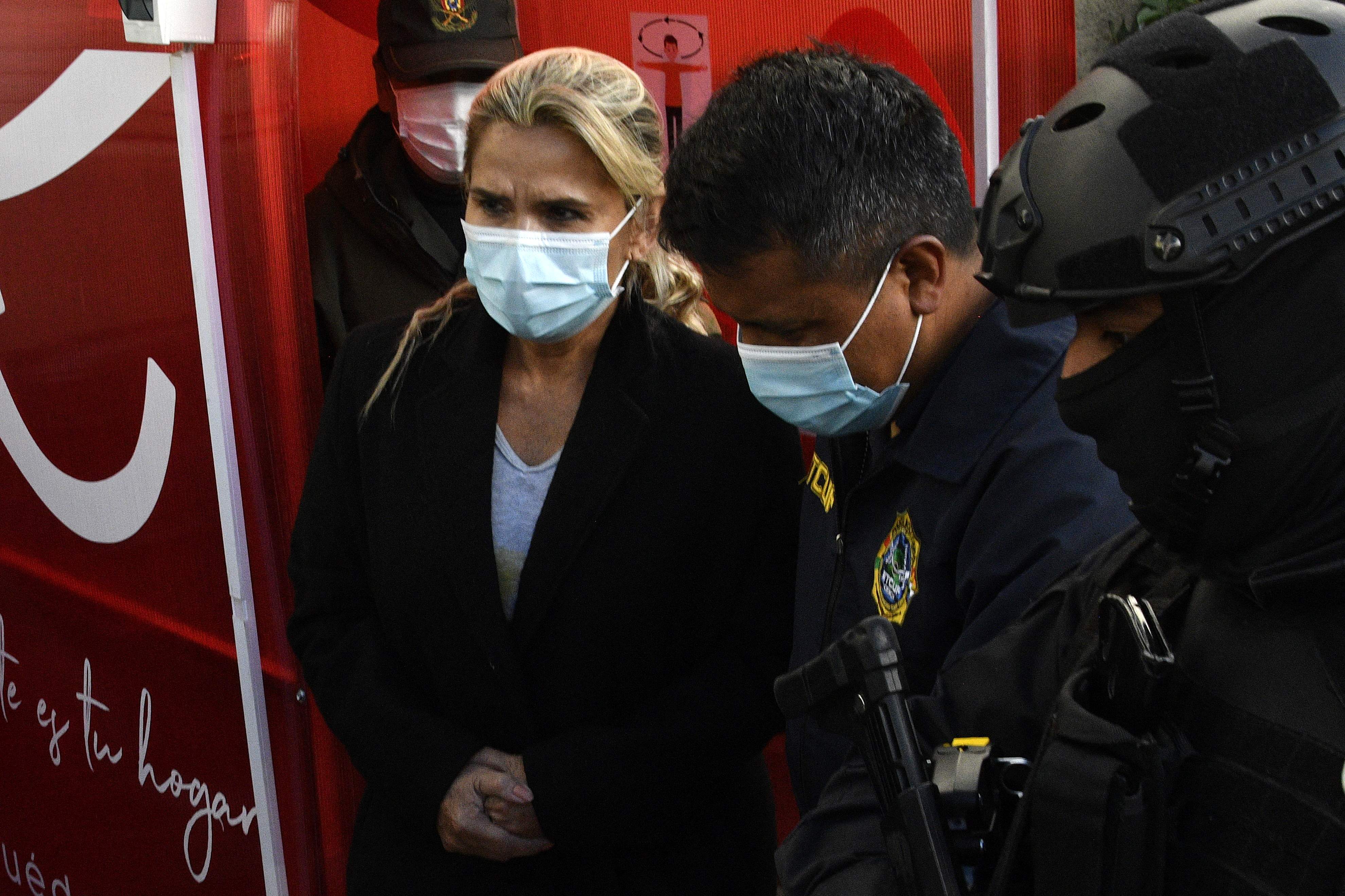 Former interim Bolivia's President Jeannine Anez (L) is escorted by police members of the Special Force against Crime (FELCC) after being arrested in La Paz, on March 13, 2021. - Bolivia's former interim president Jeanine Anez was arrested Saturday on terrorism and sedition charges over what the government claims was a coup attempt against her predecessor and political rival Evo Morales. (Photo by AIZAR RALDES / AFP)