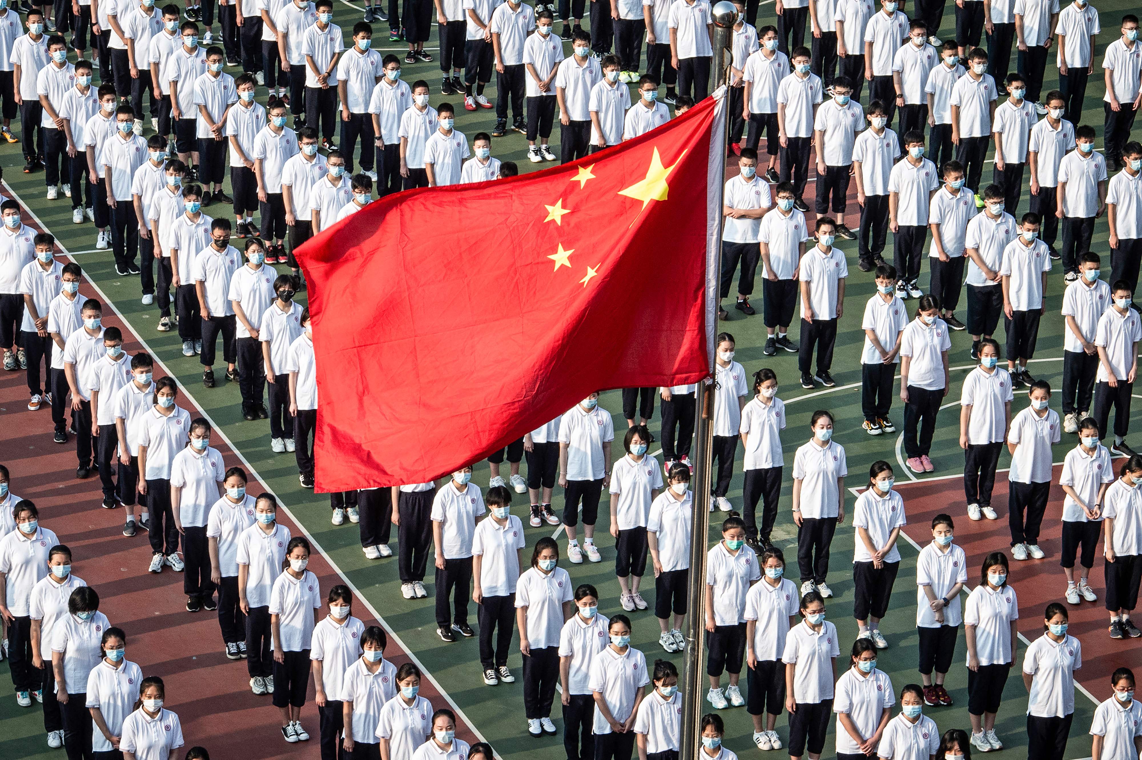 TOPSHOT - This aerial photo taken on September 1, 2021 shows students attending the opening ceremony on the first day of the new semester in Wuhan in China's central Hubei province. (Photo by STR / AFP) / China OUT