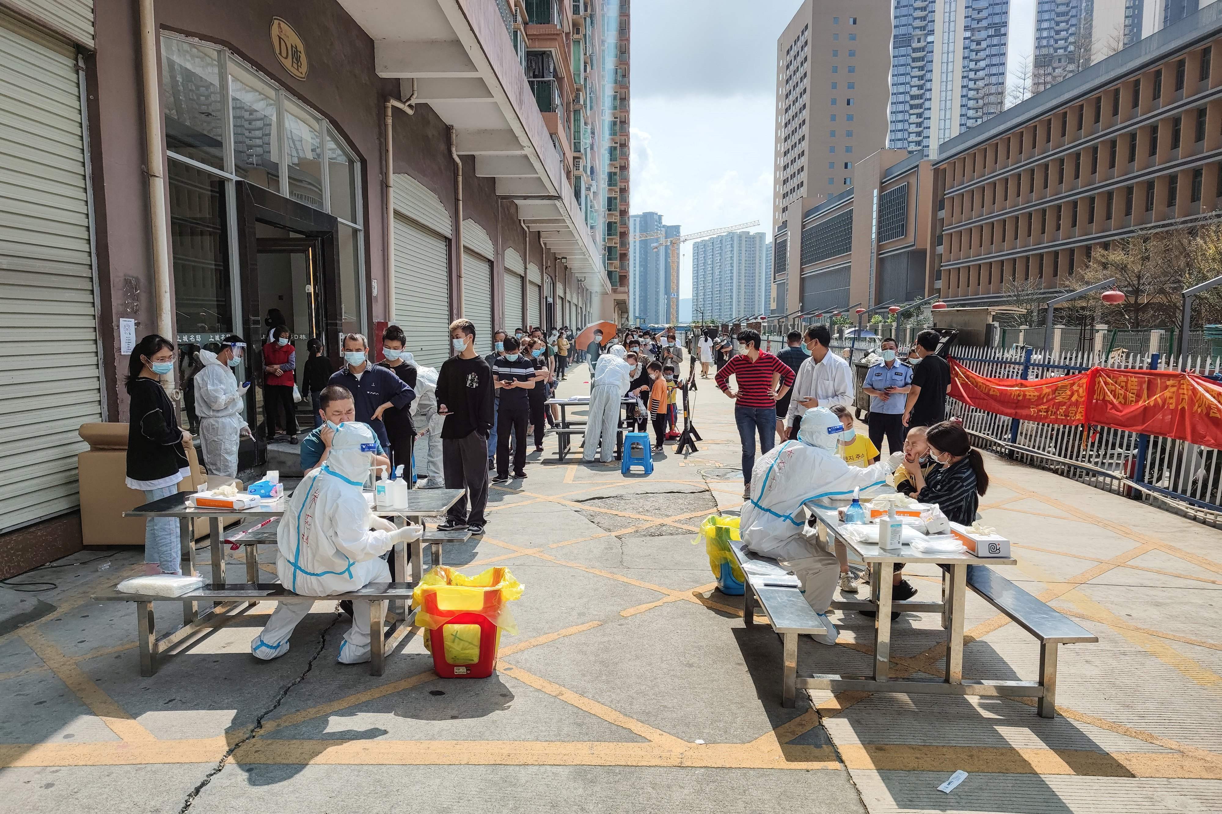 TOPSHOT - Residents queue to undergo nucleic acid tests for the Covid-19 coronavirus in Shenzhen, in China's southern Guangdong province on March 14, 2022. (Photo by AFP) / China OUT