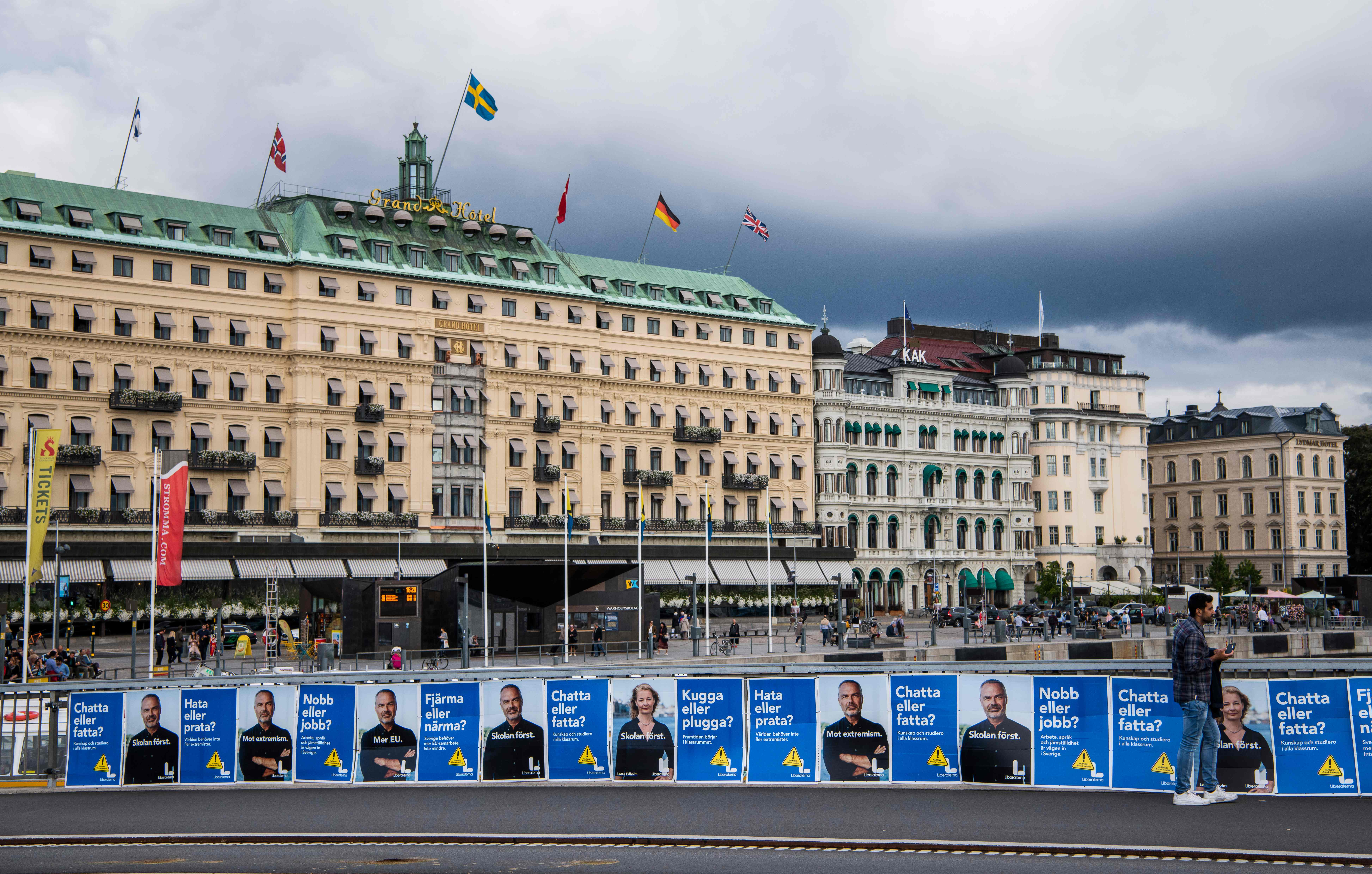 A man walks next to election posters of Jan Bjoerklund, leader of The Liberals Party in Sweden on September 1, 2018 in Stockholm. - The general elections in Sweden will take place on September 9, 2018. (Photo by Jonathan NACKSTRAND / AFP)