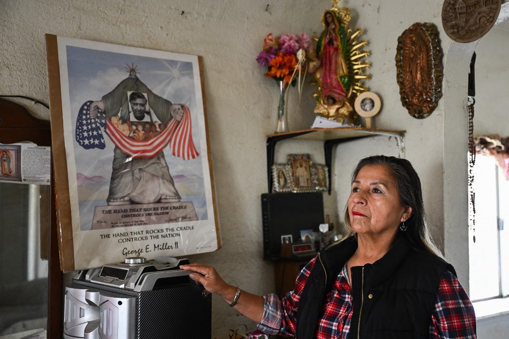 Farmworker Lourdes Cardenas stands for a portrait in her home in Fresno, California, on February 12, 2025. With planting season well under way in California, the largest agriculture-producing state in the US, fear is taking root among thousands of migrants who labor to feed a country that now seems ready to deport them. "We have to stay hidden," Lourdes Cardenas, a 62-year-old Mexican living in Fresno told AFP. "You are unsure if you will encounter the immigration authorities. We can't be free anywhere, not in schools, not in churches, not in supermarkets," said Cardenas, who has been in the United States for 22 years. (Photo by Patrick T. Fallon / AFP)