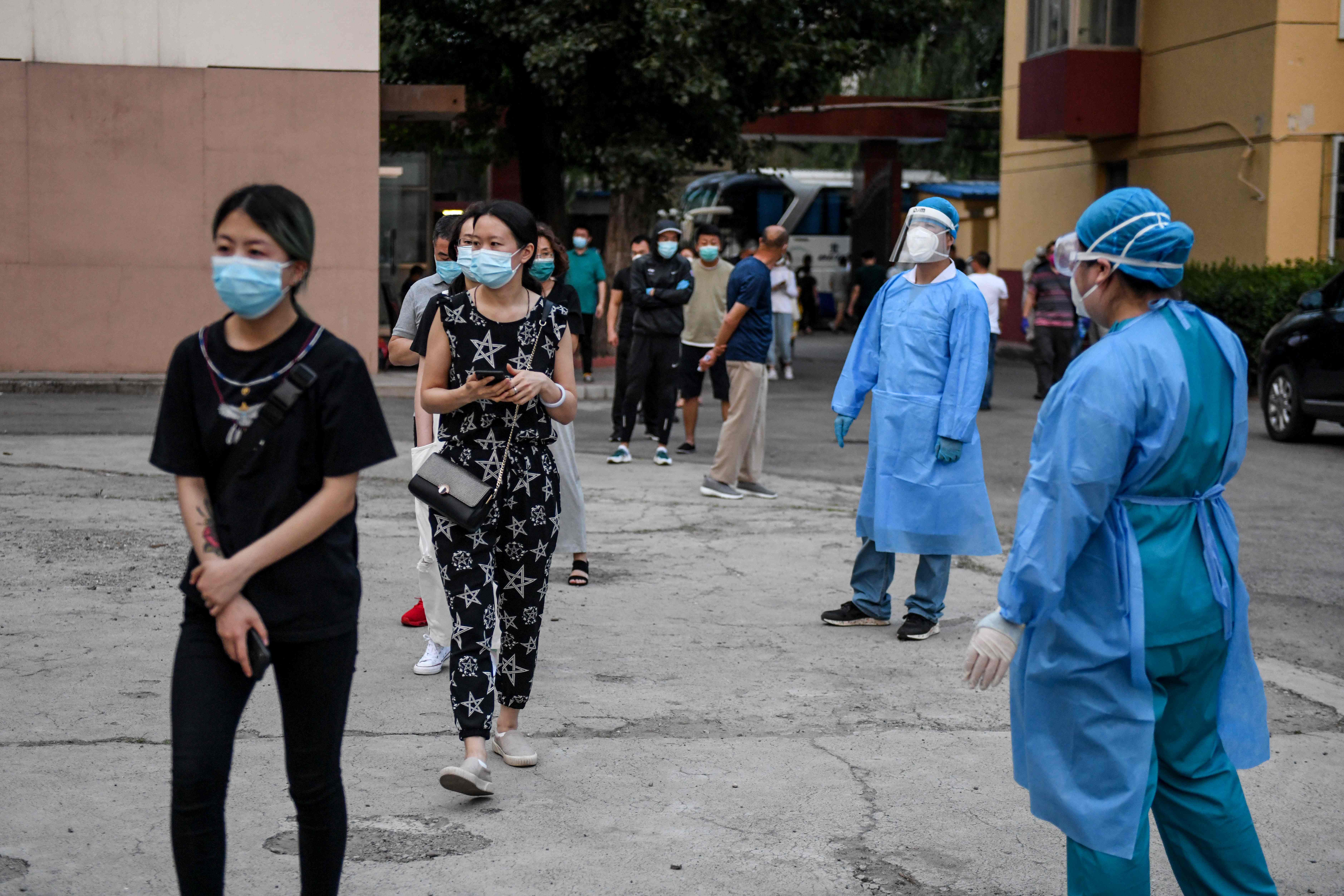 People who had their car number plates recorded in the area of the Xinfadi market where a new COVID-19 coronavirus cluster emerged last week, wait in line to do swab tests for the coronavirus at a testing centre in Beijing on June 17, 2020. - China closed schools in Beijing and restricted air travel from the capital on June 17 to halt an outbreak of coronavirus cases and dampen fears of a second wave, as India's death toll spiked. (Photo by GREG BAKER / AFP)