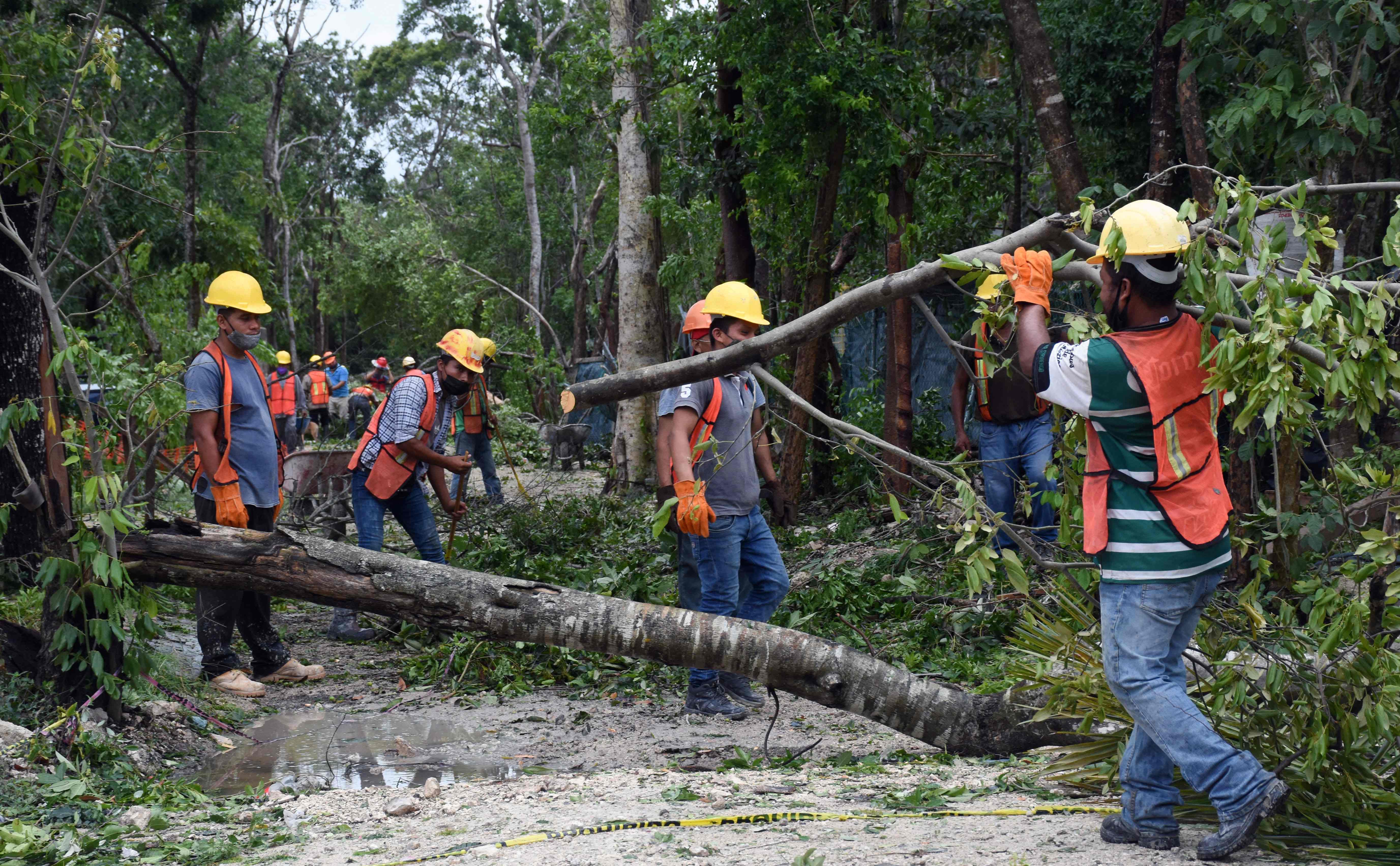 Local workers clean the streets after the passage of Hurricane Grace through the coast of Tulum, state of Quintana Roo, Mexico, on August 19, 2021. - Hurricane Grace made landfall along Mexico's eastern Yucatan peninsula on Thursday, clocking winds of 80 miles (130 kilometers) per hour as the National Hurricane Center warned of a "dangerous storm surge" in the area. (Photo by ELIZABETH RUIZ / AFP)