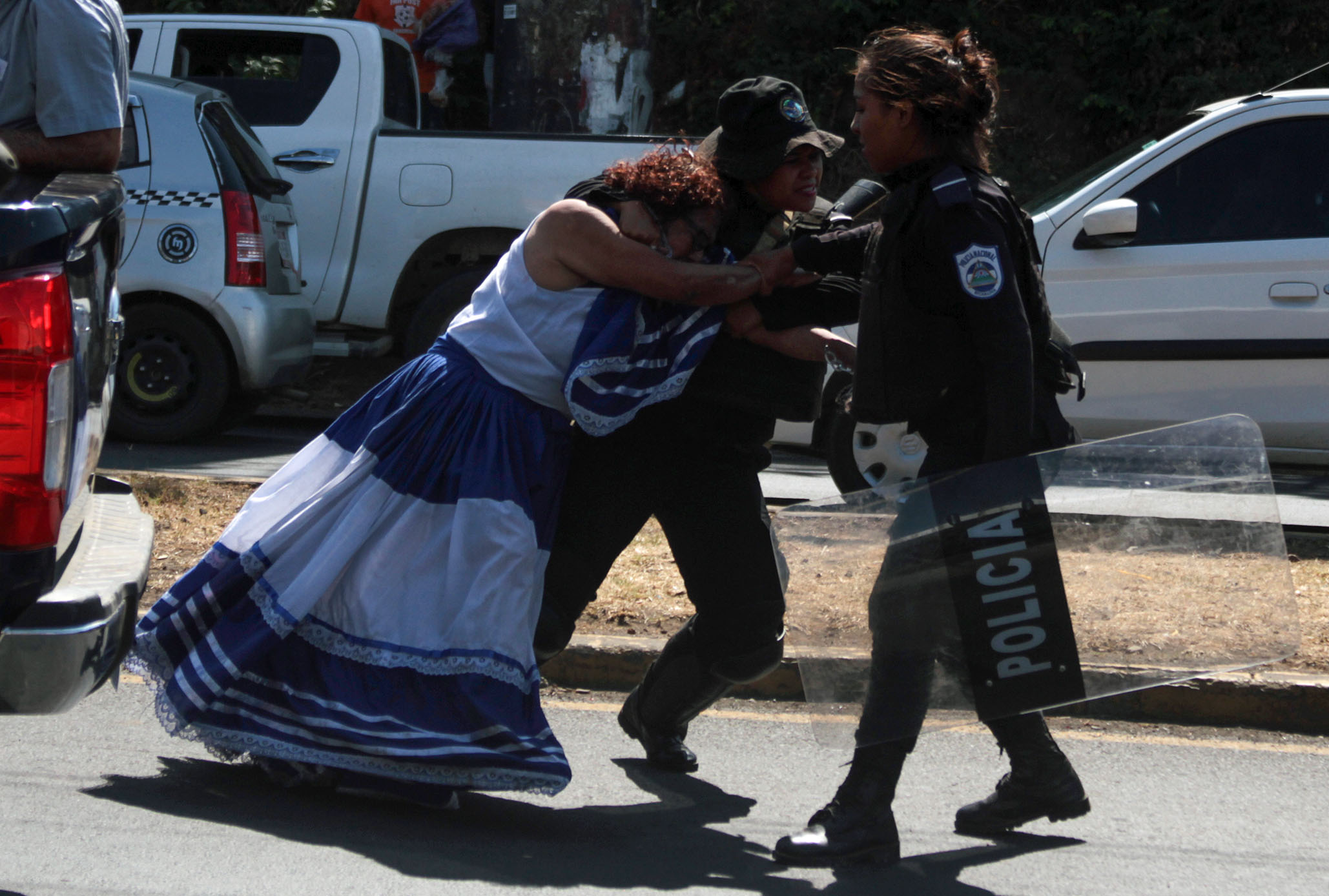 Anti-government protester Flor Ramirez (L) resists her arrest during a "National sit-in" protest, called by the opposition united front "Blue and White National Unity" in Managua on March 30, 2019. - The government of Nicaragua pledged to restore protest and press freedom rights while disarming paramilitaries under a deal reached Friday, an opposition delegate to the talks said, after a year-long political upheaval. (Photo by Maynor Valenzuela / AFP)