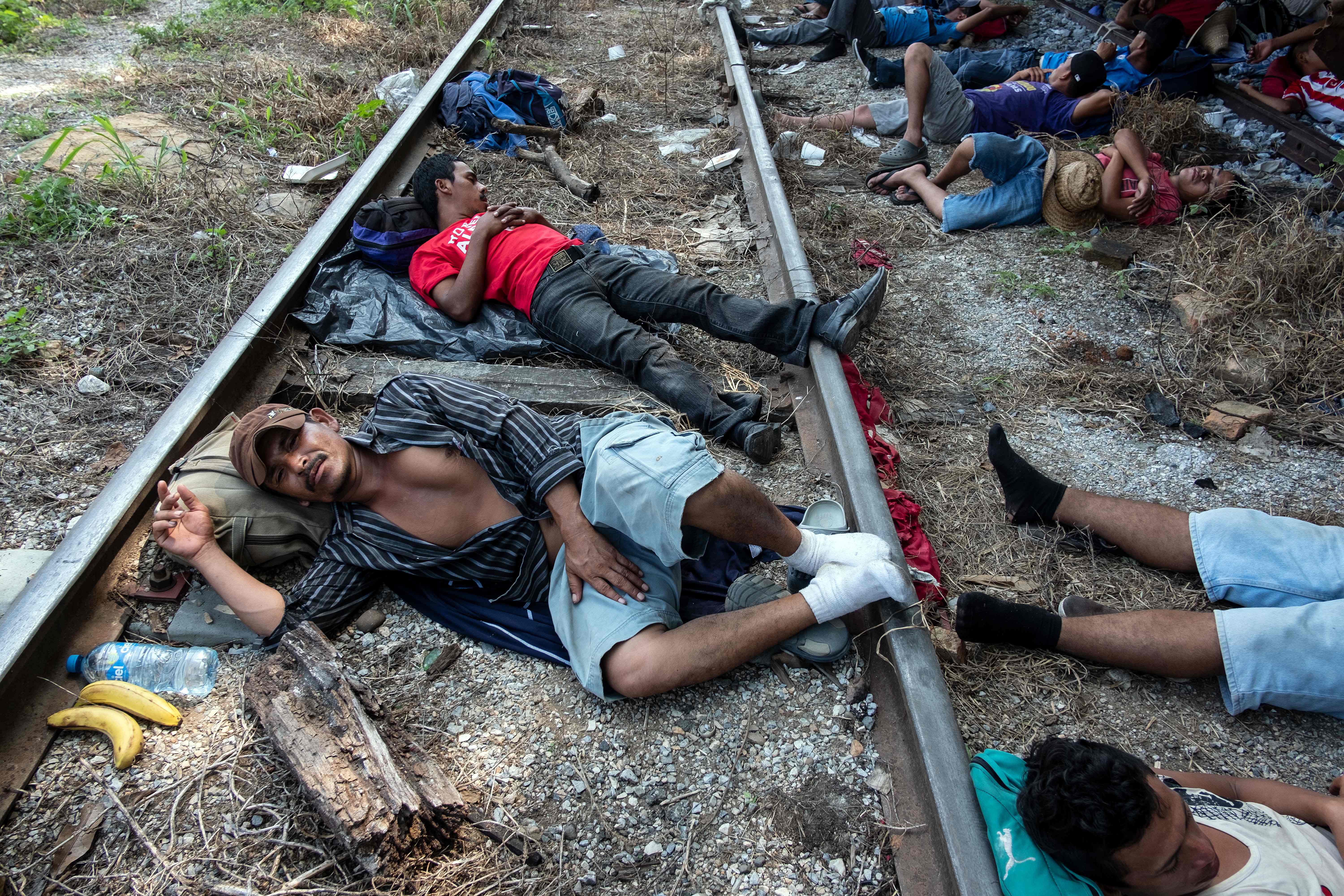 Honduran migrants heading in caravan to the US, rest on the train tracks in Arriaga in southern Mexico on October 26, 2018. - The Pentagon is expected to deploy about 800 troops to the US-Mexico border, two US officials told AFP on Thursday, after President Donald Trump said the military would help tackle a "national emergency" and called on a caravan of US-bound migrants to turn around. (Photo by GUILLERMO ARIAS / AFP)