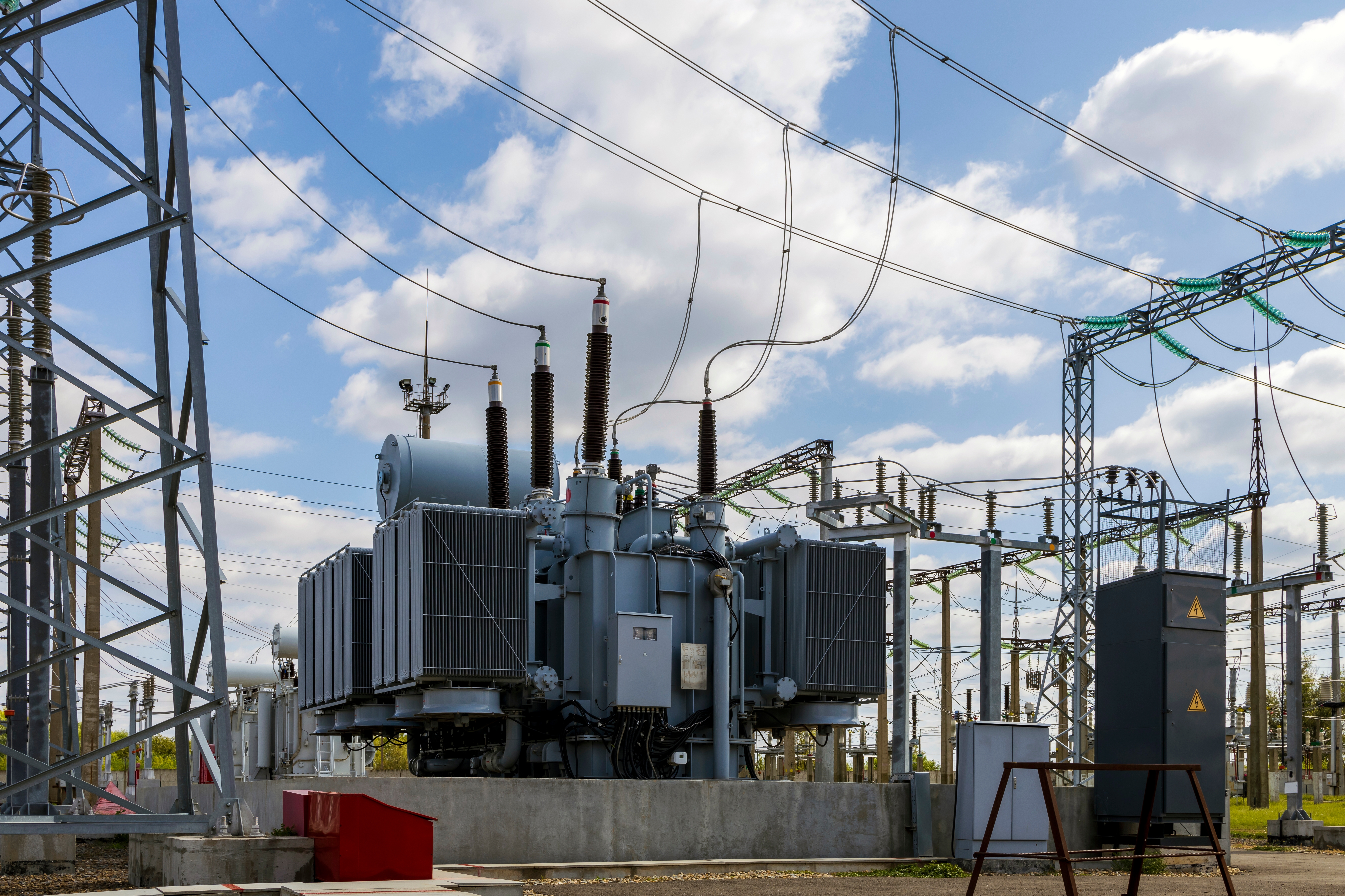 High voltage transformer with electrical insulation and electrical equipment at a power substation.