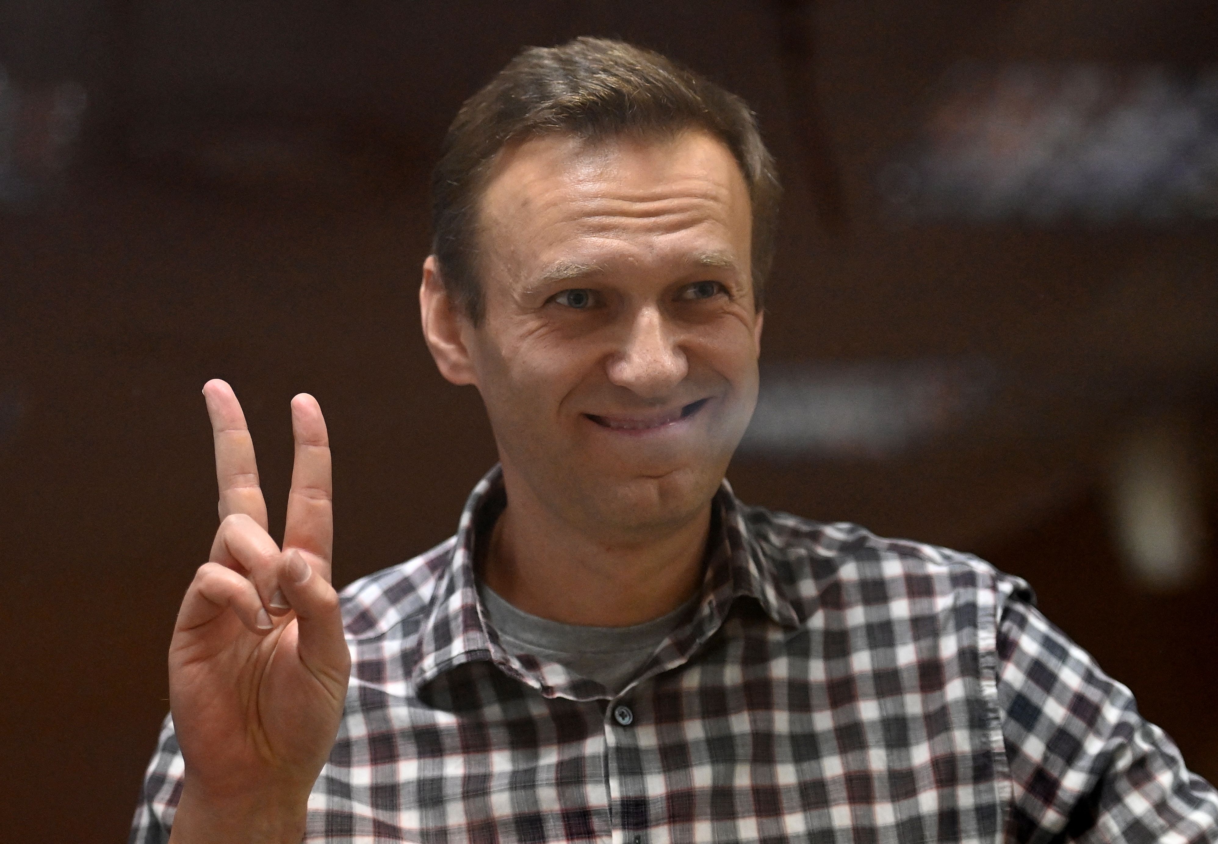 (FILES) In this file photograph taken on February 20, 2021 Russian opposition leader Alexei Navalny stands inside a glass cell during a court hearing at the Babushkinsky district court in Moscow. - Jailed Kremlin critic Alexei Navalny has been transferred from a prison hospital back to his penal colony after receiving treatment following a hunger strike, his allies said on June 7, 2021 (Photo by Kirill KUDRYAVTSEV / AFP)