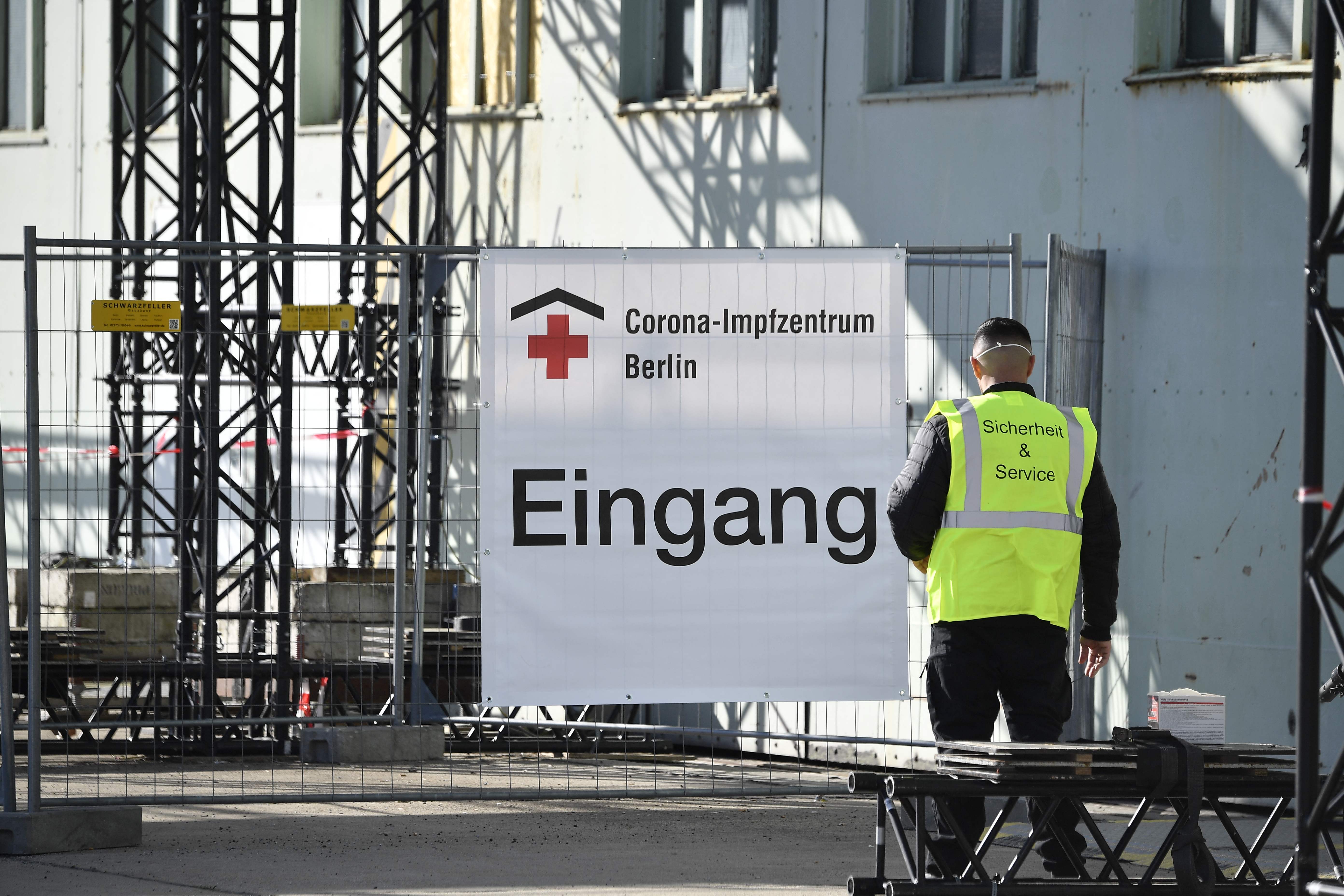 A security officer stands in front of the entrance to a new vaccination centre at the former Tempelhof airport in Berlin on March 8, 2021, amid the novel coronavirus / COVID-19 pandemic. (Photo by Tobias Schwarz / various sources / AFP)