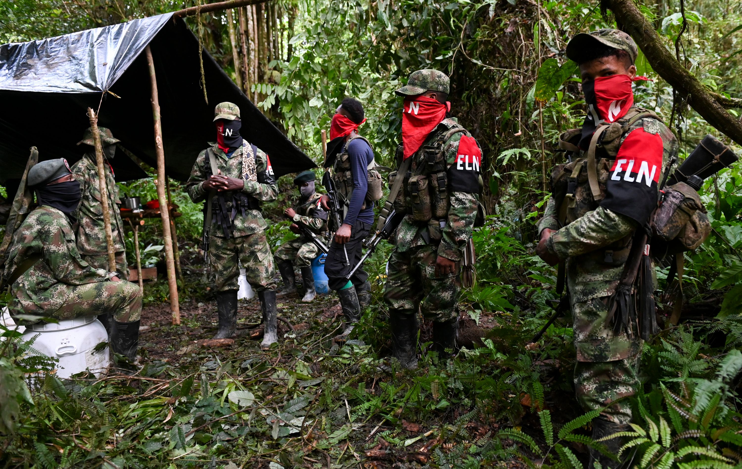 Members of the Ernesto Che Guevara front, belonging to the National Liberation Army (ELN) guerrillas, stand at an improvised camp in the Choco jungle, Colombia, on May 23, 2019. - The ELN or National Liberation Army is Colombia's last rebel army and one of the oldest guerrillas in Latin America. (Photo by Raul ARBOLEDA / AFP)
