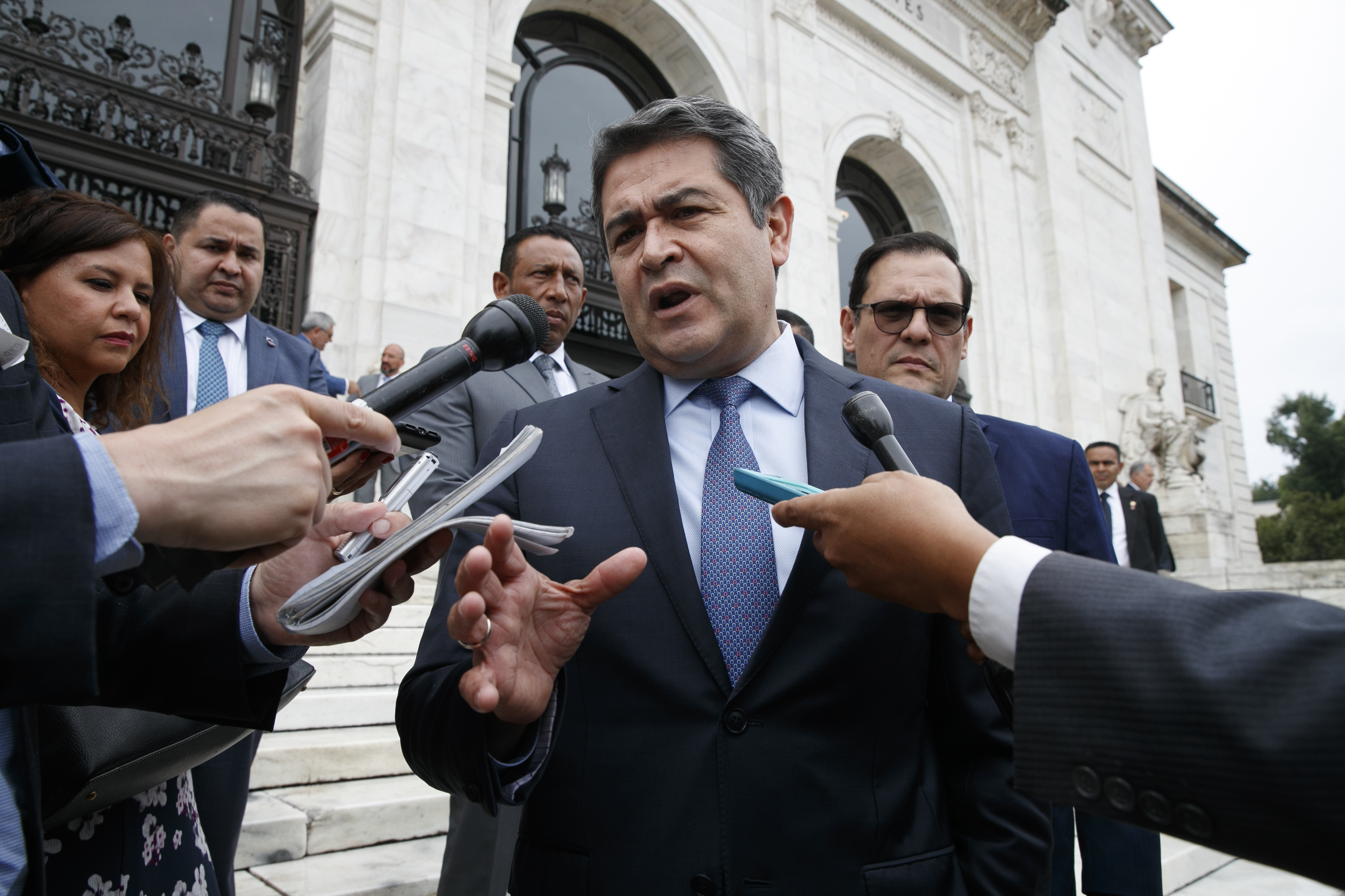 Honduran President Juan Orlando Hernandez speaks to the media Tuesday, Aug. 13, 2019, as he leaves a meeting at the Organization of American States, in Washington. (AP Photo/Jacquelyn Martin)
