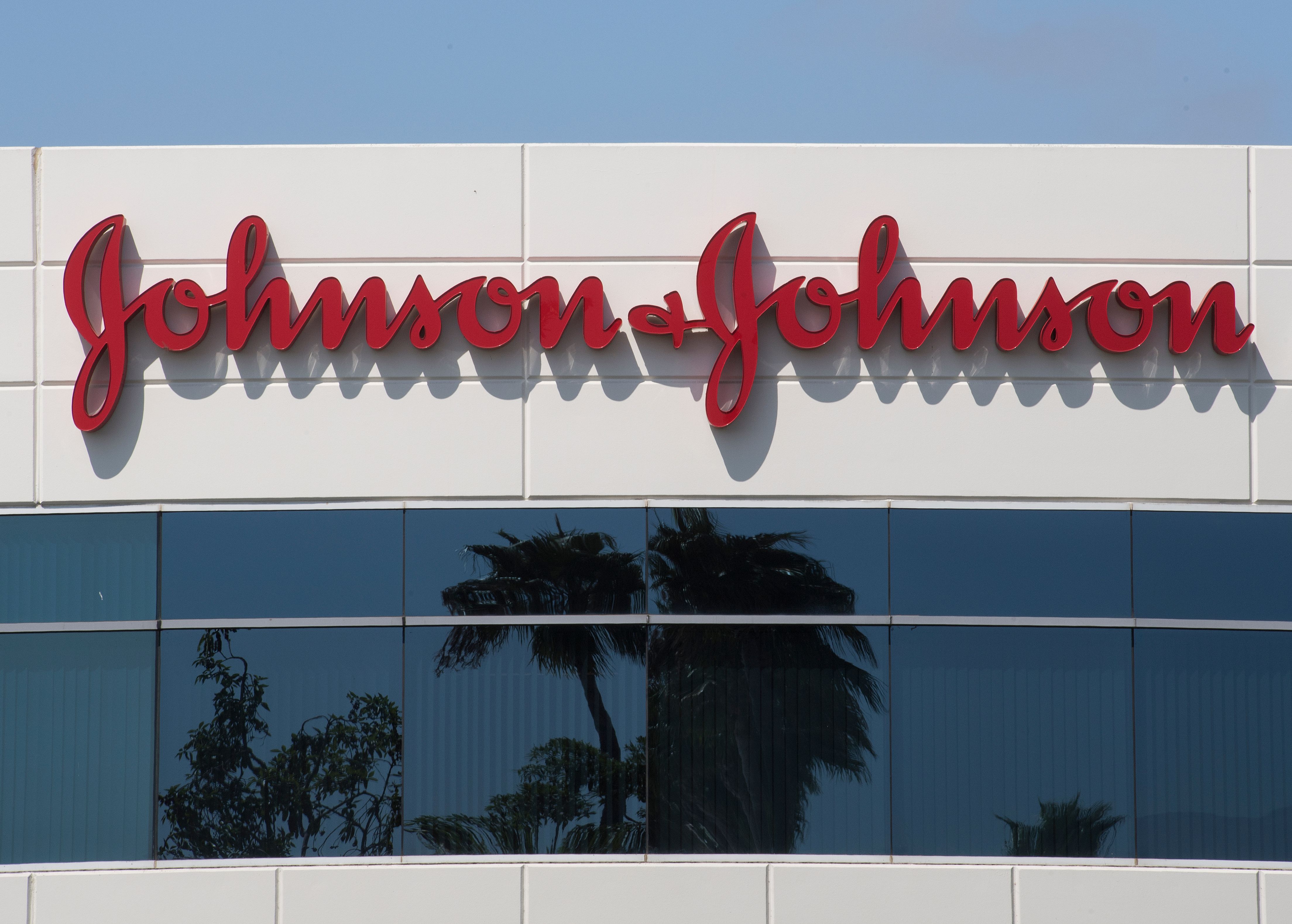 (FILES) In this file photo taken on August 28, 2019 a sign on a building at the Johnson & Johnson campus shows their logo in Irvine, California. - Johnson & Johnson said October 12, 2020, it had temporarily halted its Covid-19 vaccine trial because one of its participants had become sick. (Photo by Mark RALSTON / AFP)