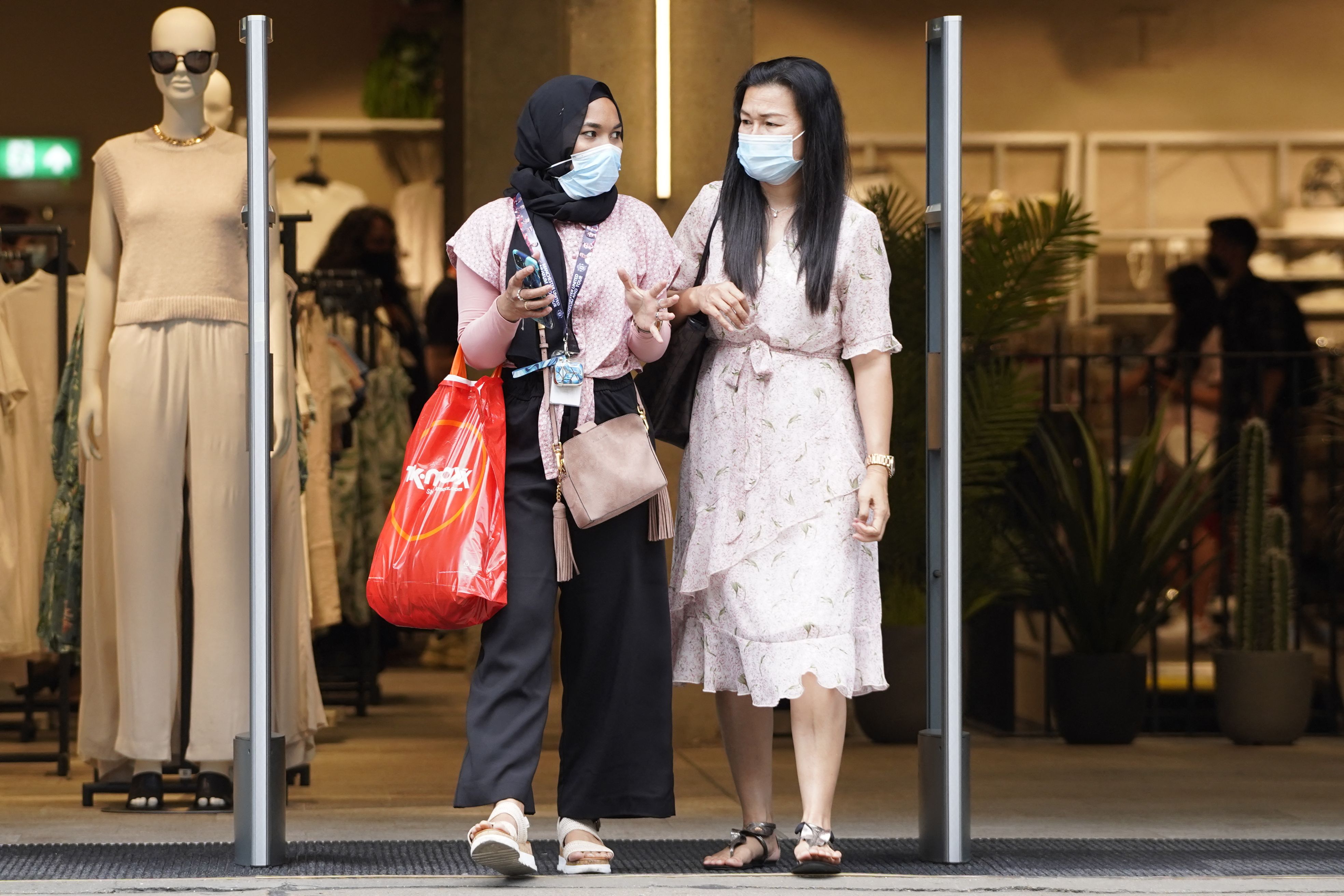 Shoppers wearing face masks shop on Oxford street in central London on July 19, 2021 as coronavirus restrictions are lifted. - England lifts virtually all of its coronavirus restrictions today, setting it at odds with the three other nations of the United Kingdom and sparking concern among scientists. (Photo by Niklas HALLE'N / AFP)