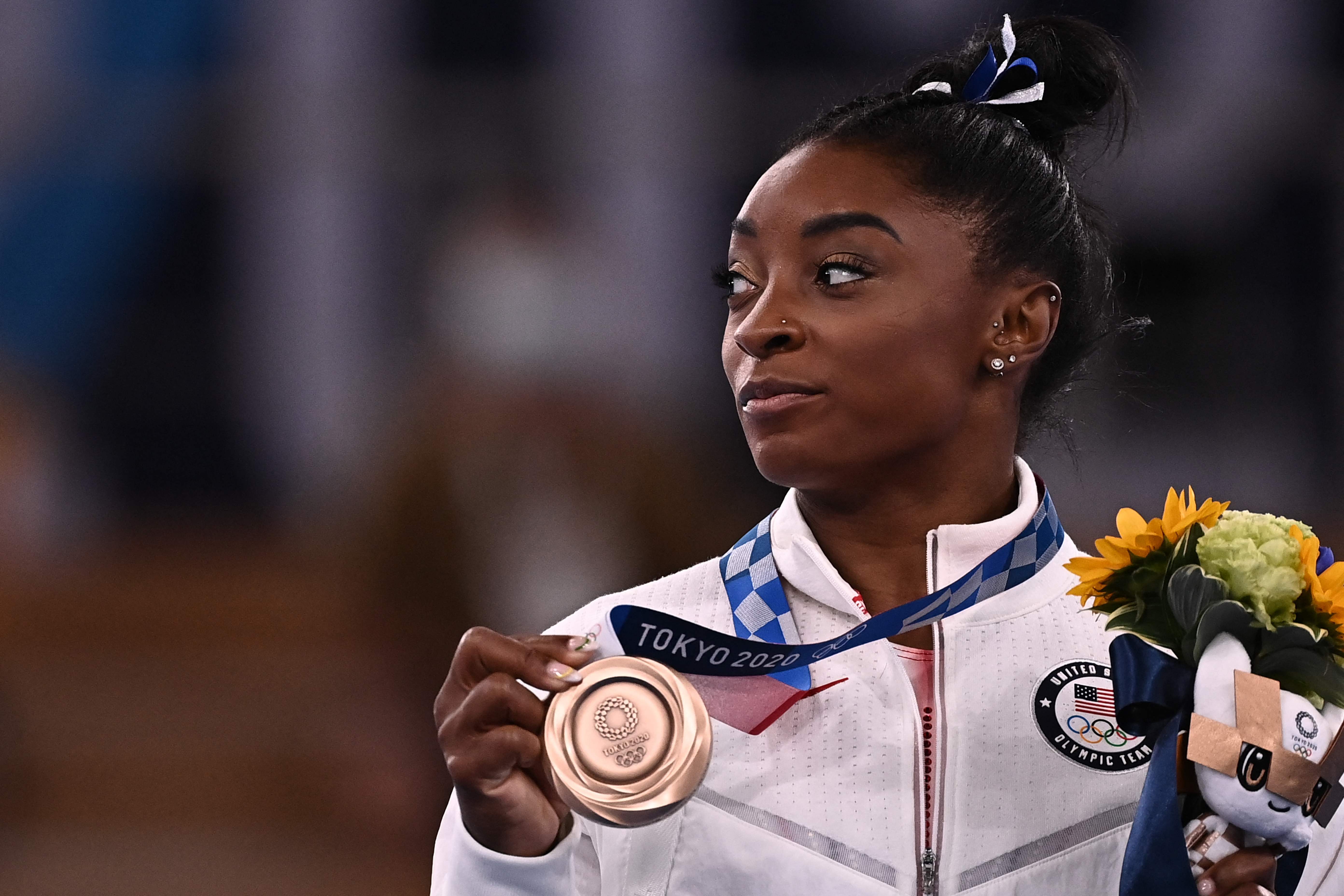 USA's Simone Biles poses with her bronze medal during the podium ceremony of the artistic gymnastics women's balance beam of the Tokyo 2020 Olympic Games at Ariake Gymnastics Centre in Tokyo on August 3, 2021. (Photo by Lionel BONAVENTURE / AFP)
