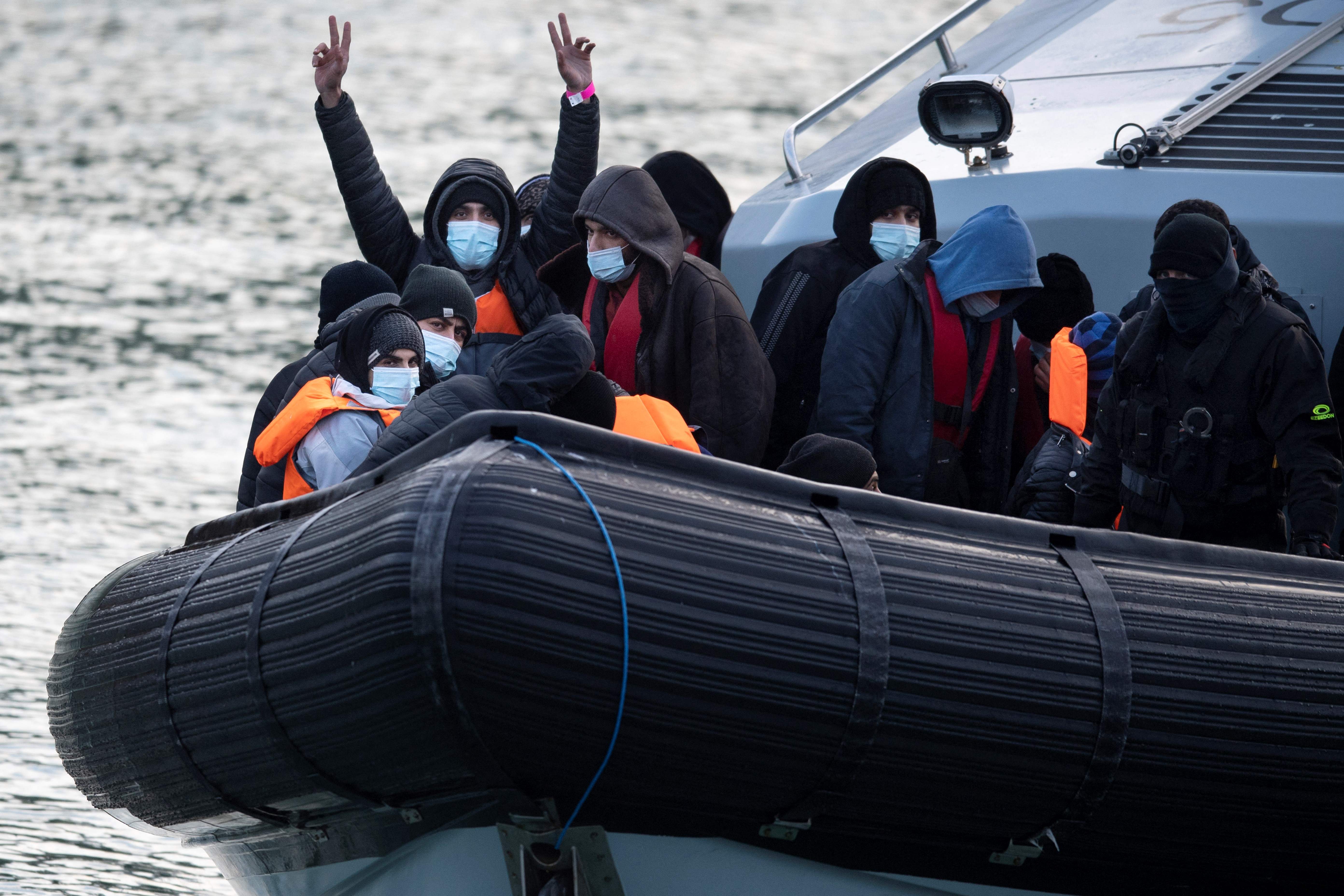 Migrants react onboard UK Border Force vessel HMC Speedwell after being picked up at sea, as they are brought into the Marina in Dover, southeast England, on December 21, 2021. - Migrants who crossed the Channel to Britain from northern France are being held in sub-standard conditions, despite government promises to improve accommodation, inspectors said on Thursday. Britain has this year faced an unprecedented number of arrivals from migrants using small boats to cross the Channel. The situation has become a political headache for Britain, which vowed to "take back control " of its borders after leaving the European Union -- and strained ties with France. (Photo by Ben STANSALL / AFP)