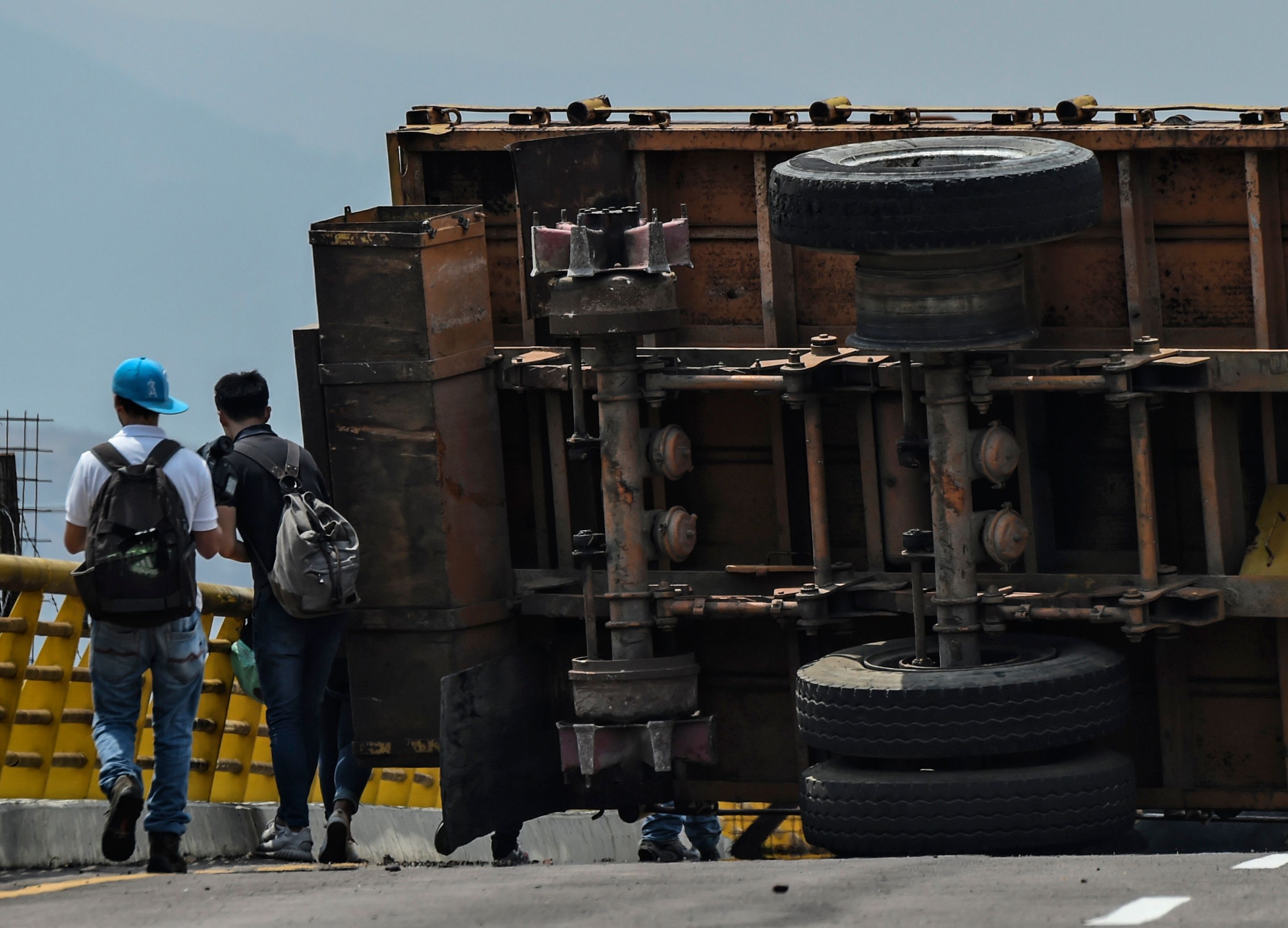 TOPSHOT - Journalists are seen at the blocked Tienditas bridge in Urena, Venezuela, on the border with Colombia, on February 20, 2019. - Nicolas Maduro's government suspended "indefinite flights" and set sail for Cura�ao, Aruba and Bonaire, and announced the revision of relations with the three Caribbean islands in their offensive to prevent the entry of humanitarian aid to Venezuela on Saturday. (Photo by Juan BARRETO / AFP)