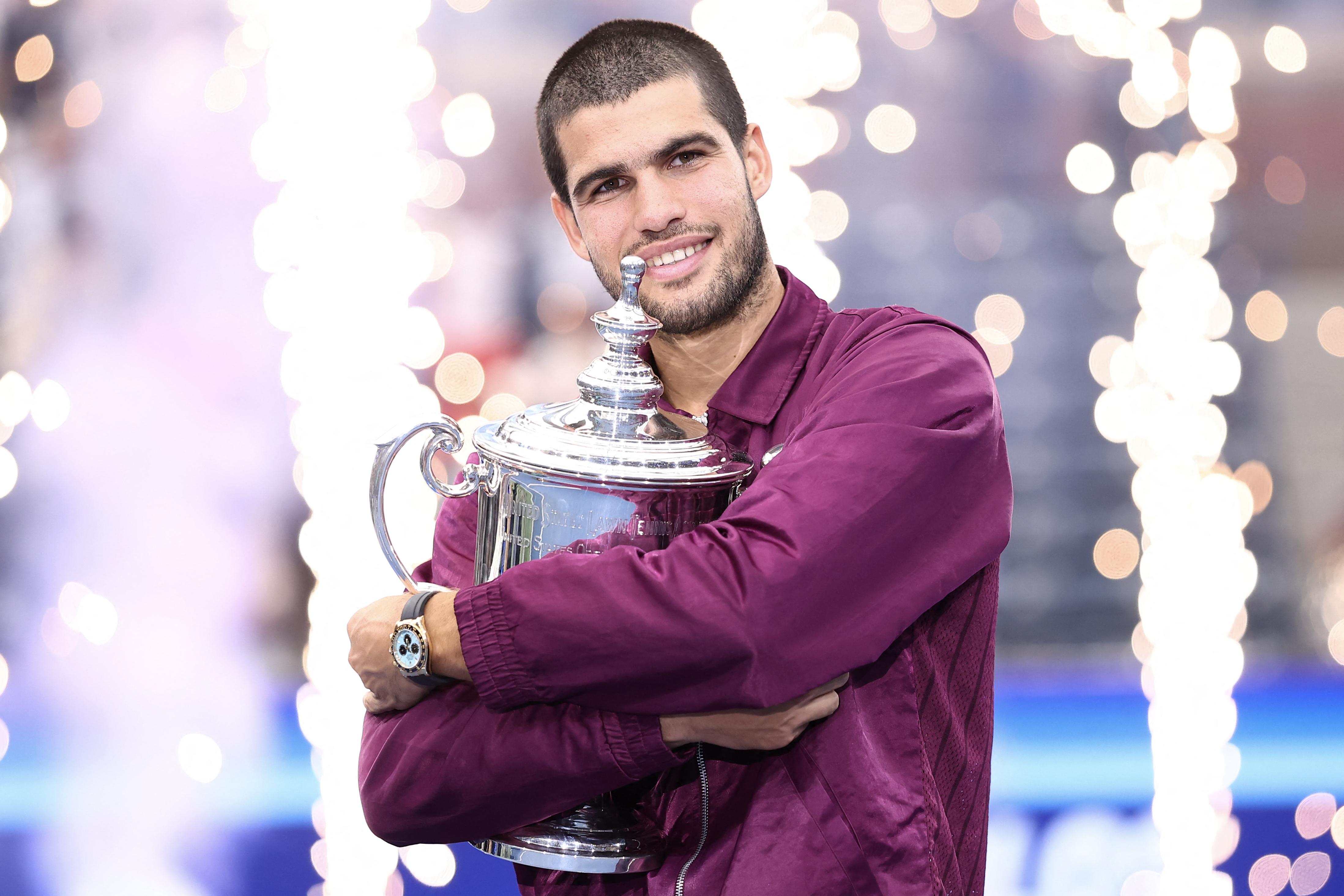 El tenista español Carlos Alcaraz abraza el trofeo de campeón tras imponerse al italiano Jannik Sinner en la final del Abierto de Estados Unidos.
