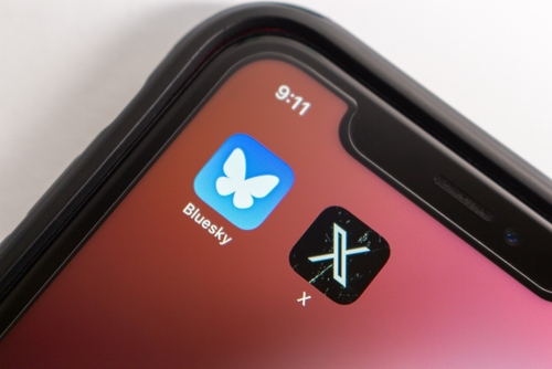 Icono de la aplicación Bluesky en la pantalla de un teléfono móvil, representando su enfoque en protocolos abiertos que posibilitan el desarrollo de feeds y aplicaciones sociales personalizadas.