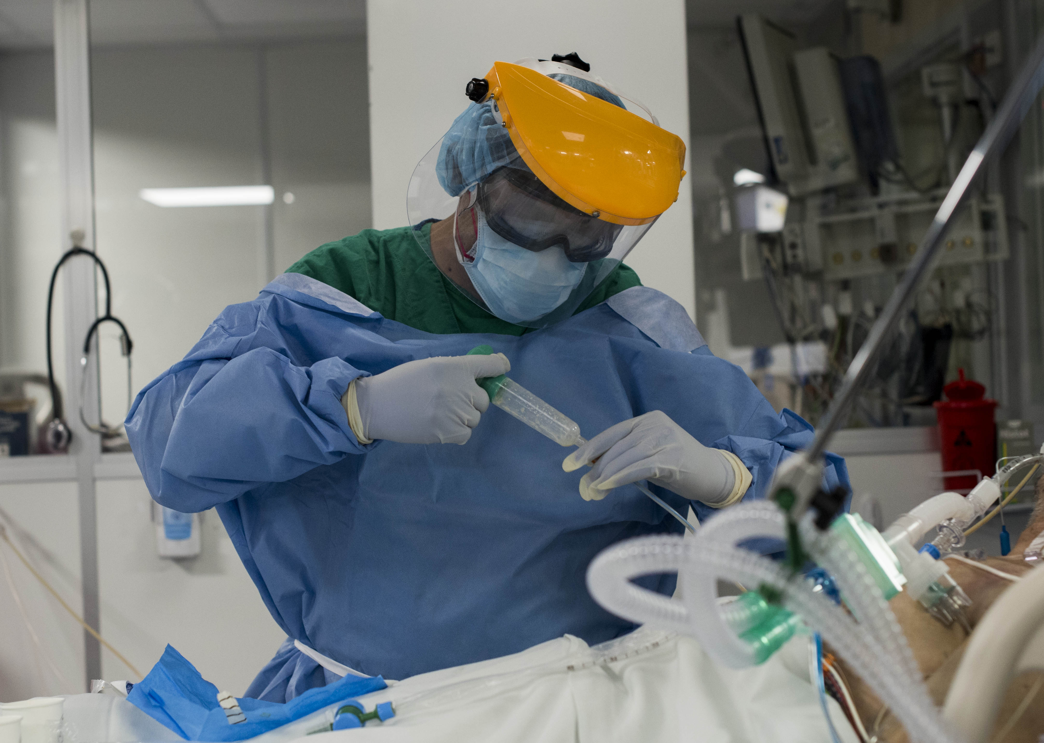 (FOTOS PARA REVISTA DOMINICAL) Un funcionario atiende a un paciente con coronavirus en la UCI del San Juan de Dios. Foto: Carlos González/ HSJD