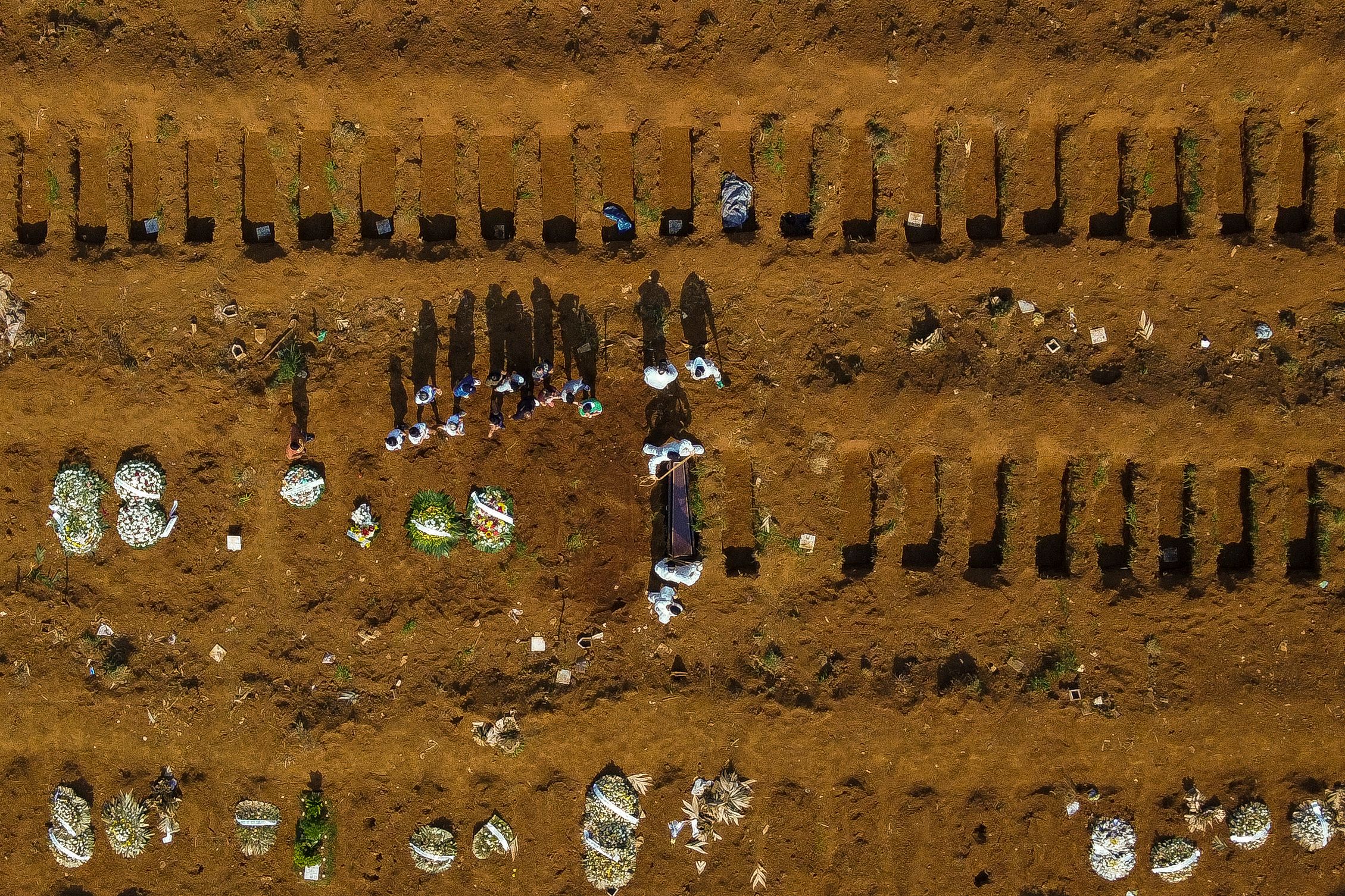 TOPSHOT - Aerial view of a burial at the Vila Formosa cemetery during the COVID-19 coronavirus pandemic, in Sao Paulo, Brazil, on March 23, 2021. - Brazil's daily Covid-19 death toll soared past 3,000 for the first time Tuesday as the hard-hit country struggled to contain a surge of cases that has pushed many hospitals to breaking point. (Photo by Miguel SCHINCARIOL / AFP)