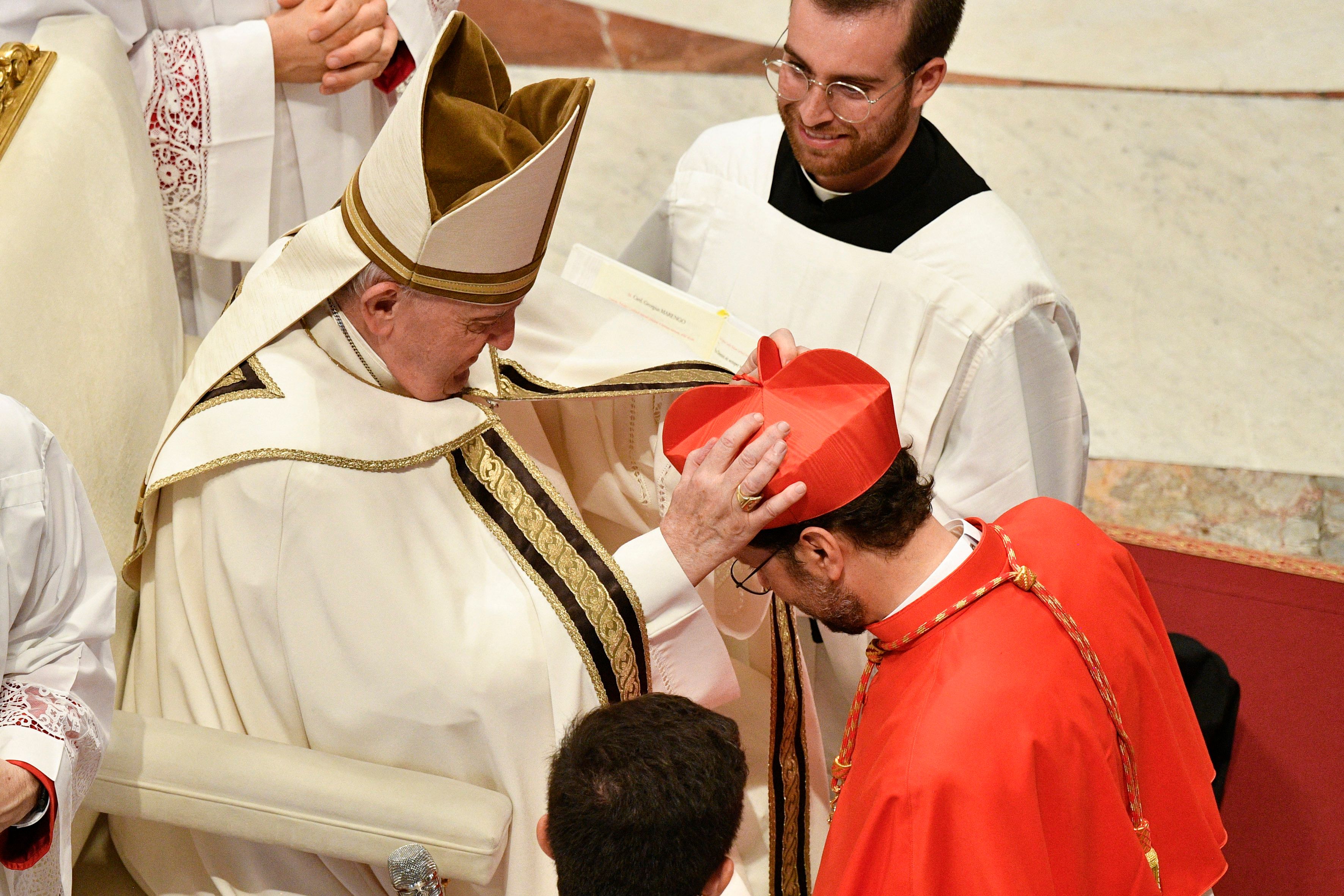 This photo taken and handout on August 27, 2022 by The Vatican Media shows Pope Francis putting the biretta hat on the head of Monsignor Giorgio Marengo as he elevates him to the rank of Cardinal during a consistory to create 20 new cardinals at St. Peter's Basilica in The Vatican. (Photo by Handout / VATICAN MEDIA / AFP) / RESTRICTED TO EDITORIAL USE - MANDATORY CREDIT "AFP PHOTO / VATICAN MEDIA / HANDOUT" - NO MARKETING NO ADVERTISING CAMPAIGNS - DISTRIBUTED AS A SERVICE TO CLIENTS